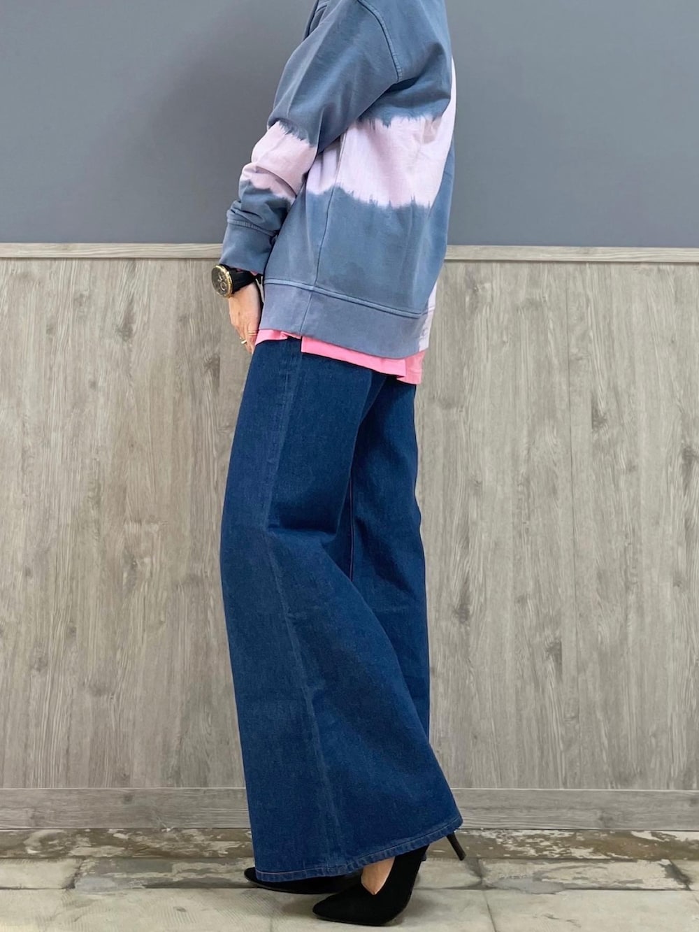 ブルー系のデニムパンツ、シルバー系のショルダーバッグ、パープル系のトップスを着用したレディースの春コーディネートの2枚目の写真