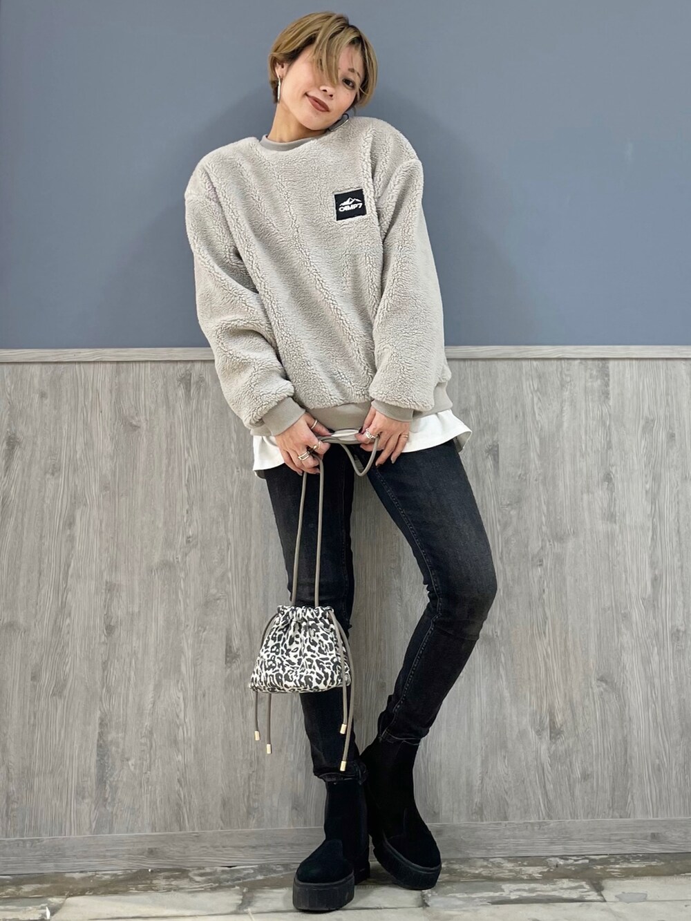 ブラック系のデニムパンツ、ホワイト系のTシャツ/カットソー、グレー系のスウェットを着用したレディースの冬コーディネートの4枚目の写真