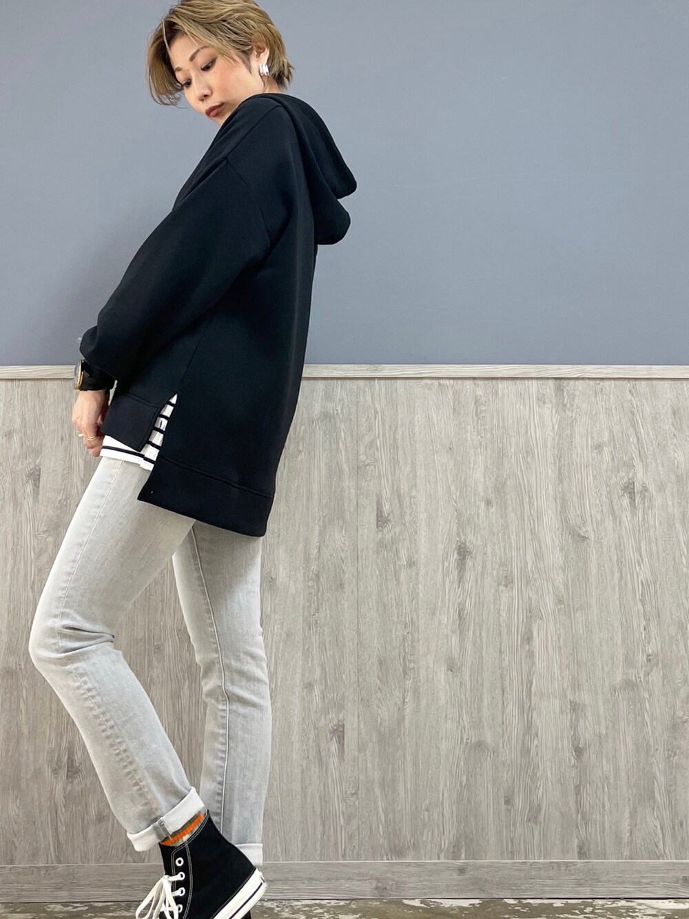 シルバー系のデニムパンツ、ブラック系のスニーカー、ブラック系のパーカーを着用したレディースの冬コーディネートの2枚目の写真