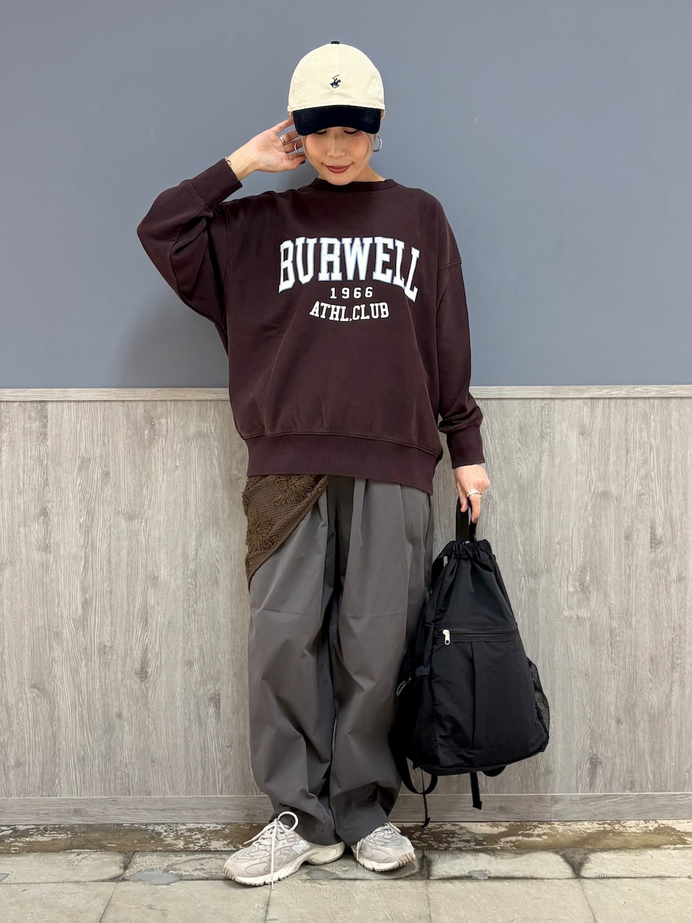 レッド系のスウェット、グレー系のその他パンツ、ブラック系のバックパック/リュックを着用したレディースの秋コーディネートの3枚目の写真