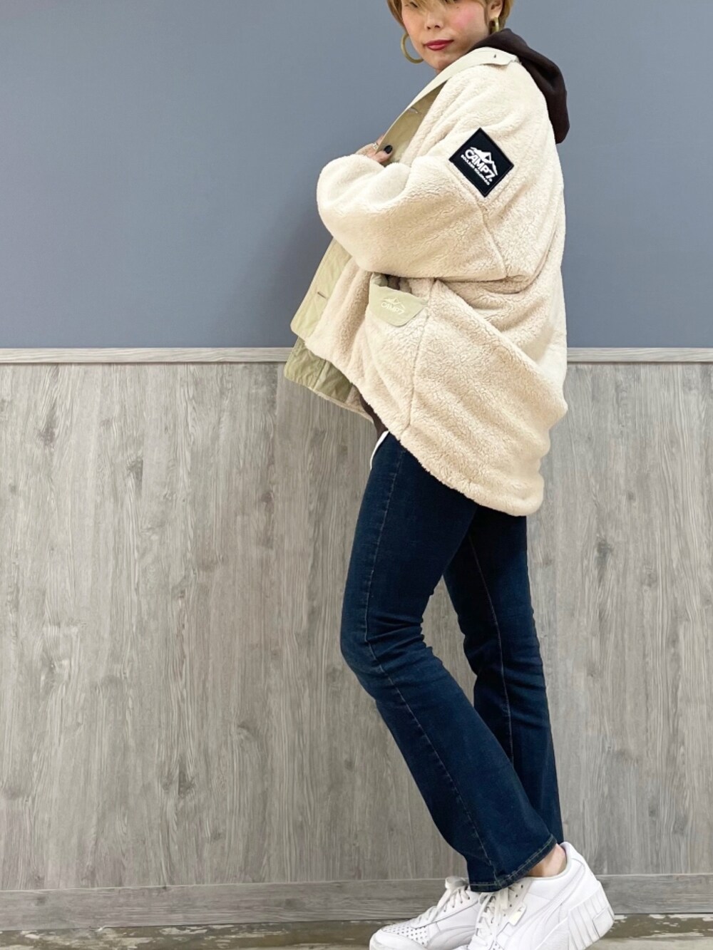 ブルー系のその他パンツ、ホワイト系のシューズ、ブラウン系のパーカーを着用したレディースの秋コーディネートの2枚目の写真