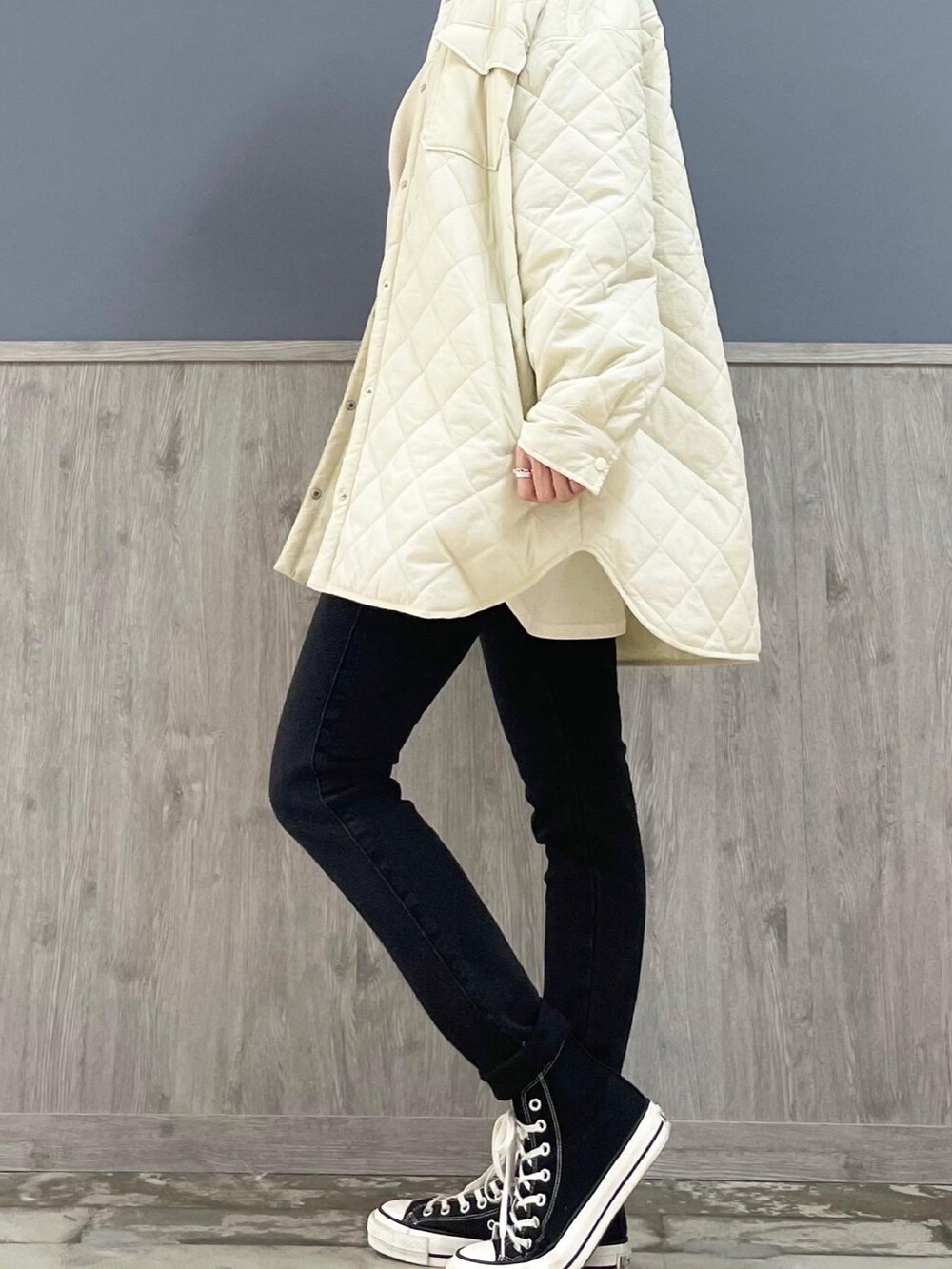 ブラック系のショルダーバッグ、ホワイト系のニット/セーター、ホワイト系のTシャツ/カットソーを着用したレディースの冬コーディネートの4枚目の写真