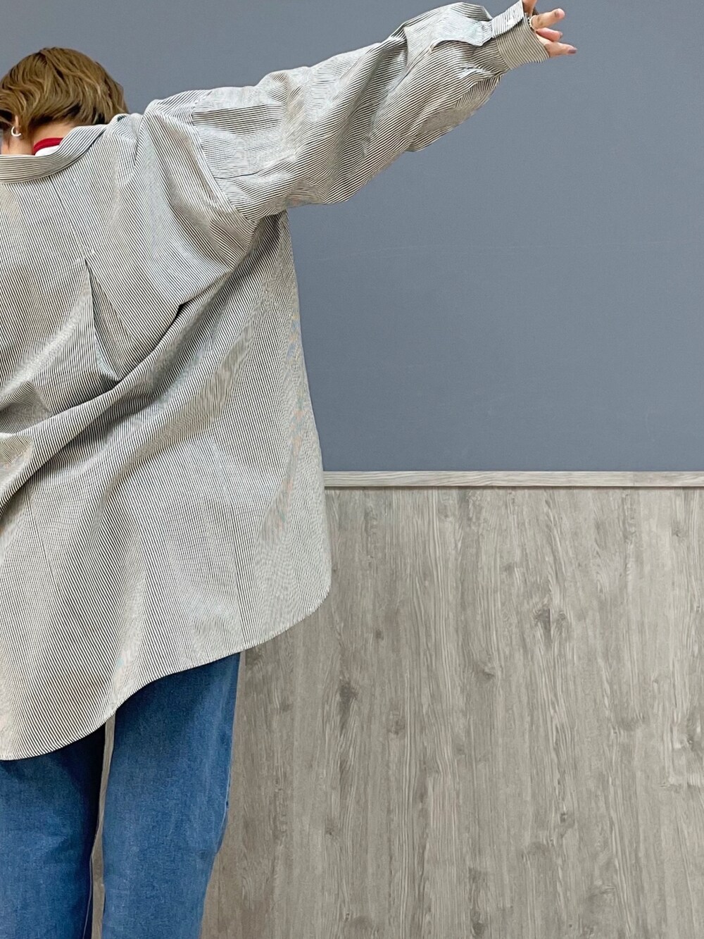 レッド系のTシャツ/カットソー、ブルー系のシャツ/ブラウス、ブルー系のデニムパンツを着用したレディースの冬コーディネートの4枚目の写真