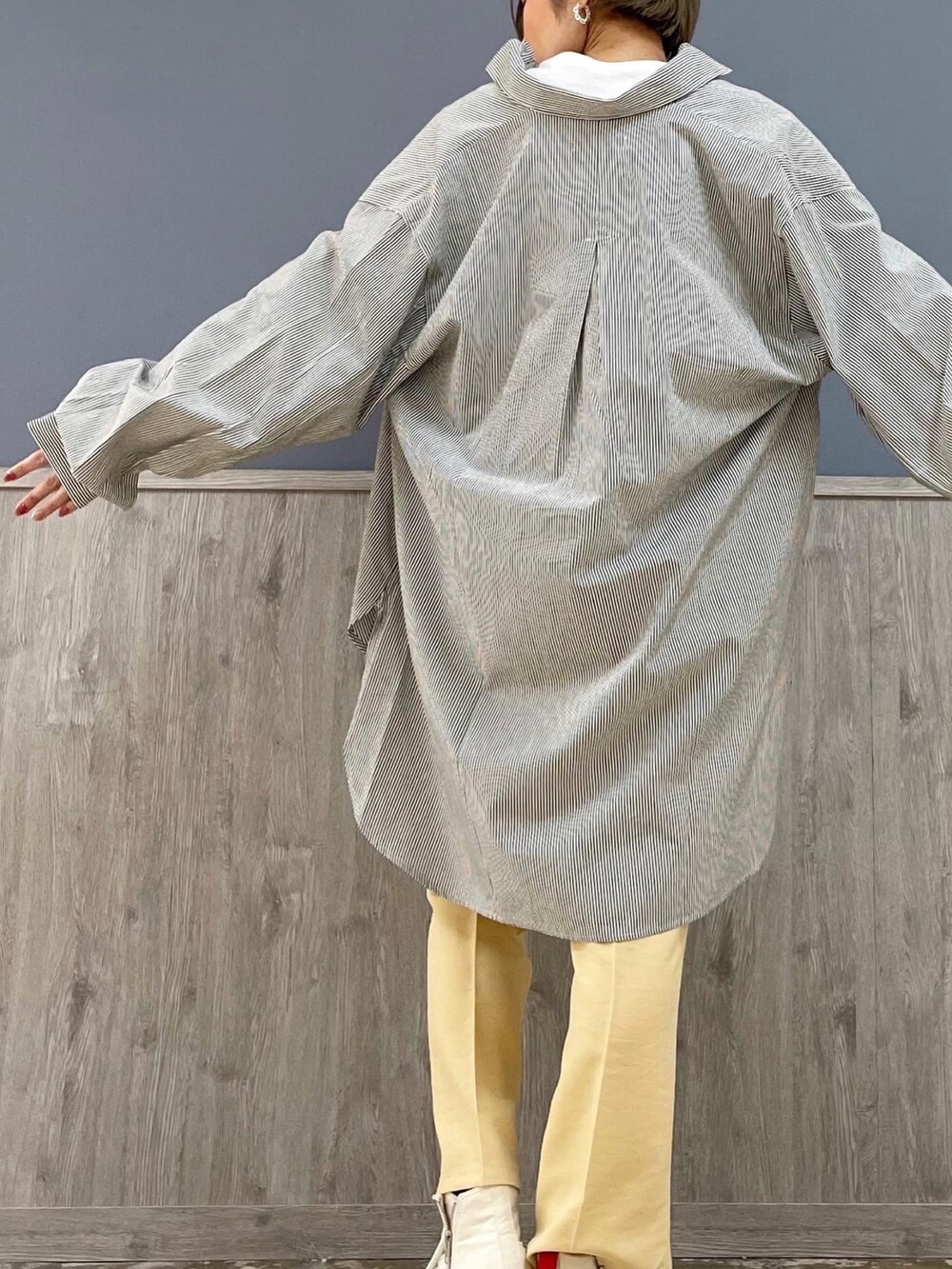 シルバー系のショルダーバッグ、ホワイト系のジャケット/アウター、ブルー系のシャツ/ブラウスを着用したレディースの冬コーディネートの5枚目の写真