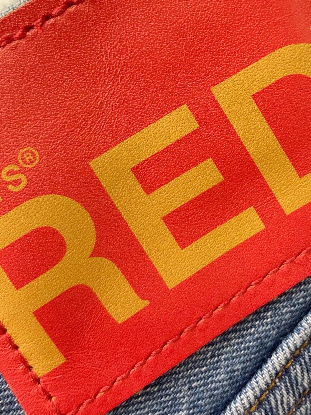 レッド系のTシャツ/カットソー、ブルー系のシャツ/ブラウス、ブルー系のデニムパンツを着用したレディースの冬コーディネートの2枚目の写真