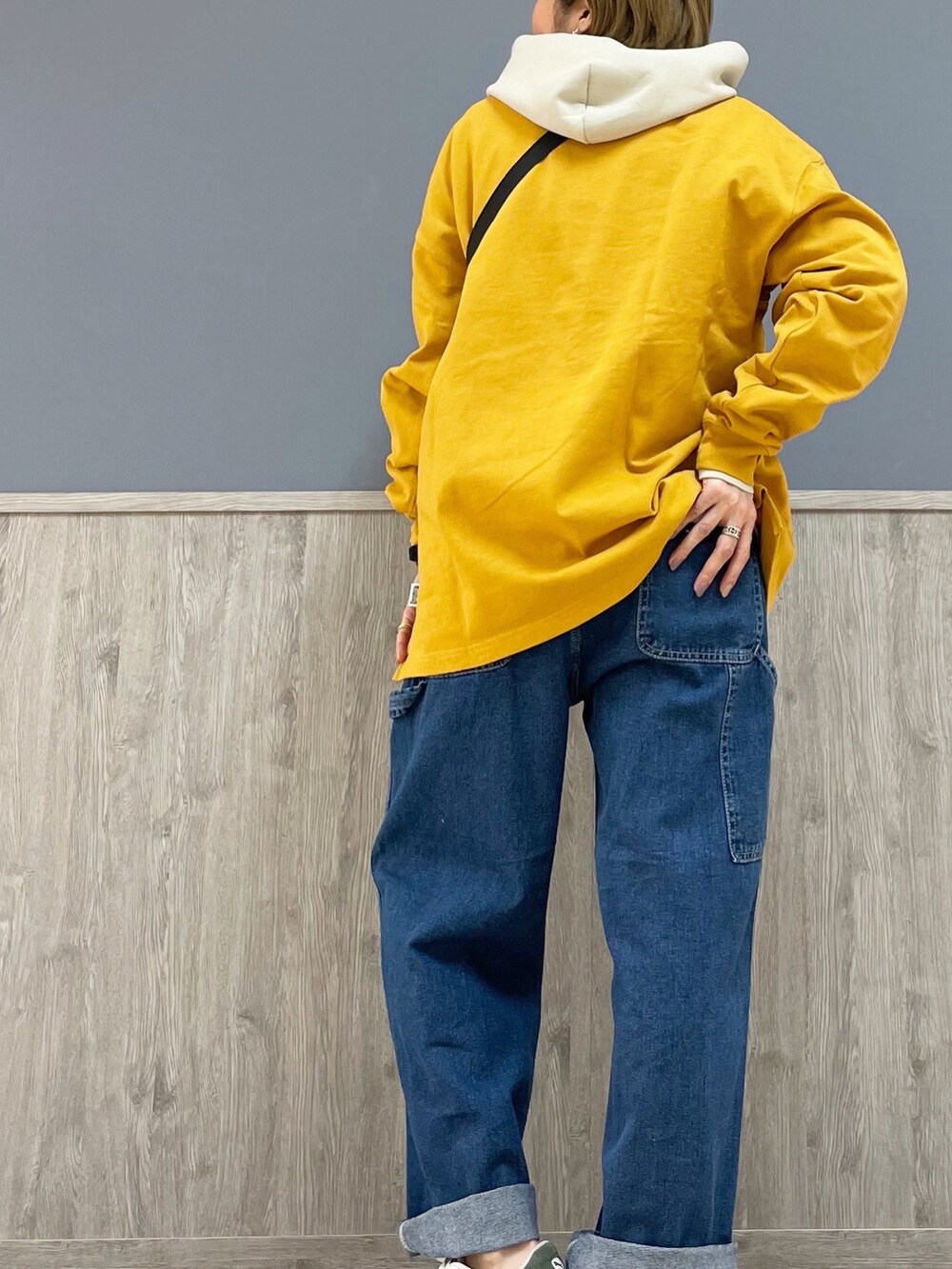 ブルー系のショルダーバッグ、イエロー系のTシャツ/カットソー、ベージュ系のパーカーを着用したレディースの冬コーディネートの3枚目の写真