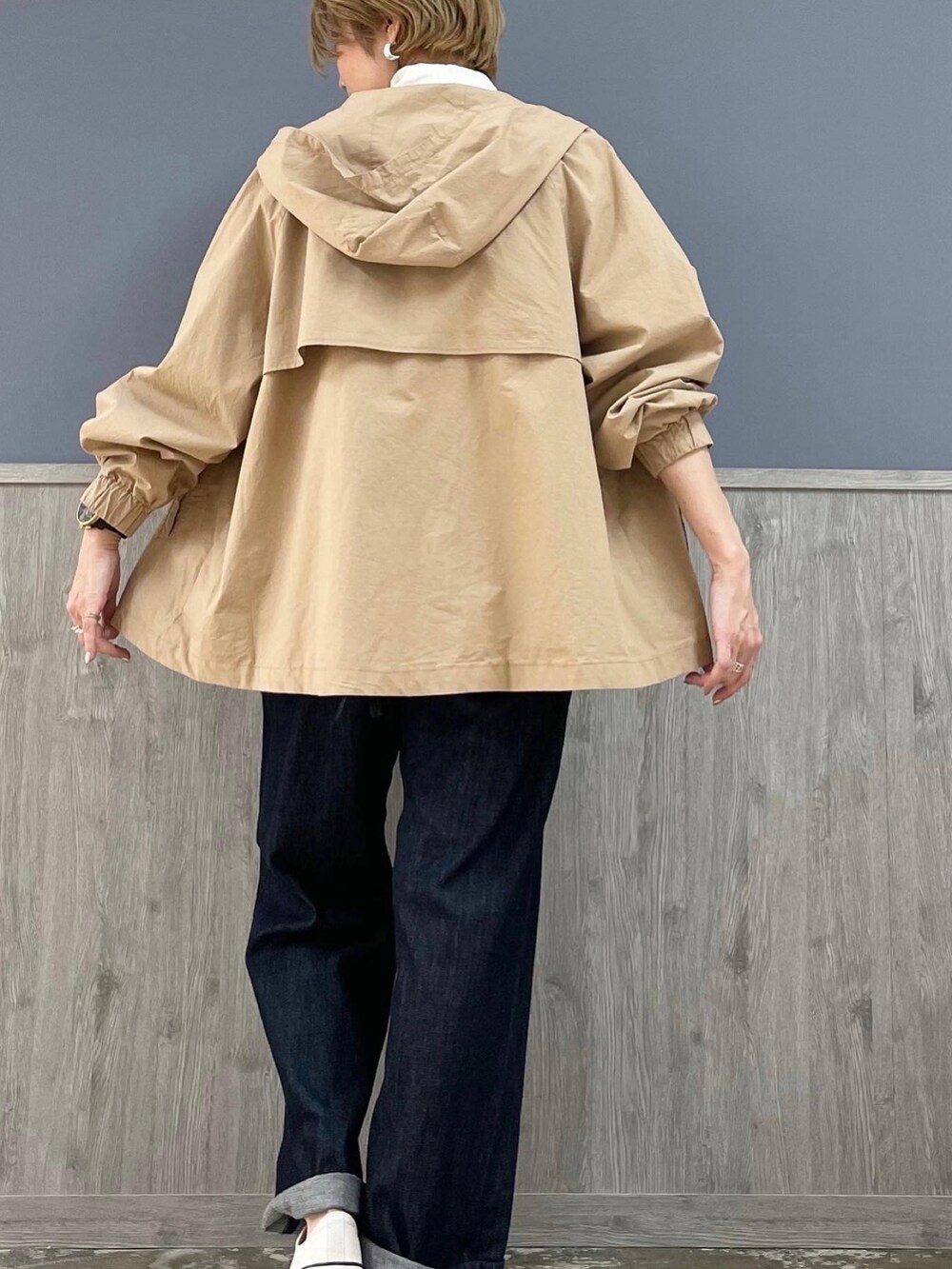 グレー系のショルダーバッグ、ベージュ系のマウンテンパーカー、ブルー系のサロペット/オーバーオールを着用したレディースの春コーディネートの3枚目の写真