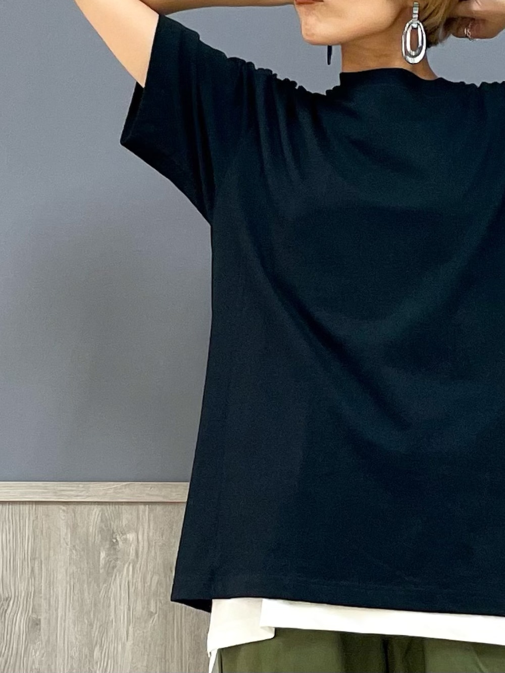 グリーン系のカーゴパンツ、ブラック系のサンダル、ブラック系のショルダーバッグを着用したレディースの夏コーディネートの2枚目の写真