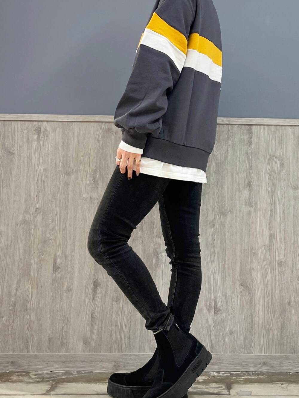 ブラック系のデニムパンツ、ベージュ系のトートバッグ、ブラック系のスニーカーを着用したレディースの冬コーディネートの3枚目の写真