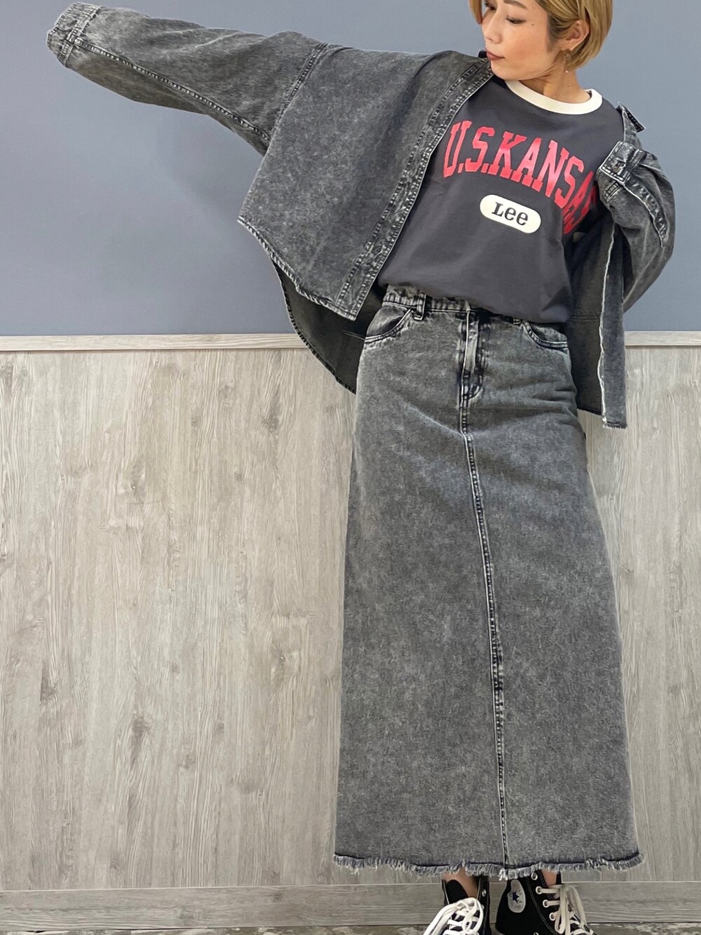 レッド系のショルダーバッグ、ブラック系のデニムスカート、グレー系のTシャツ/カットソーを着用したレディースの春コーディネートの3枚目の写真