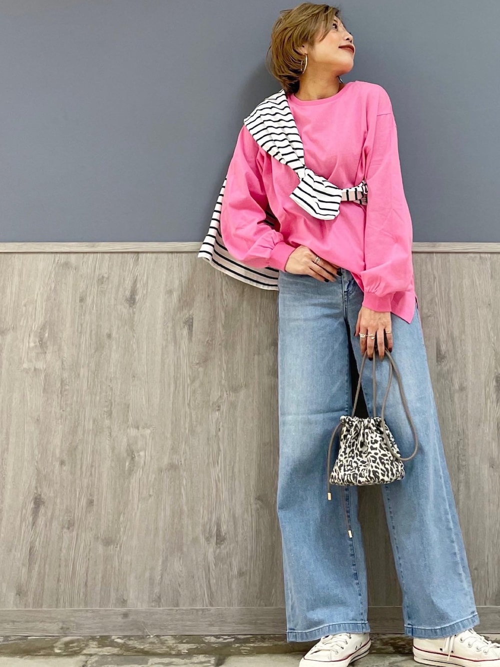 ブルー系のデニムパンツ、グレー系のショルダーバッグ、ピンク系のTシャツ/カットソーを着用したレディースの春コーディネートの3枚目の写真