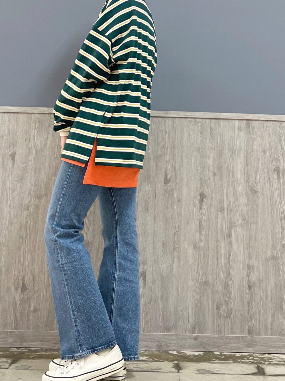 レッド系のトートバッグ、ブルー系のデニムパンツ、グリーン系のTシャツ/カットソーを着用したレディースの春コーディネートの2枚目の写真