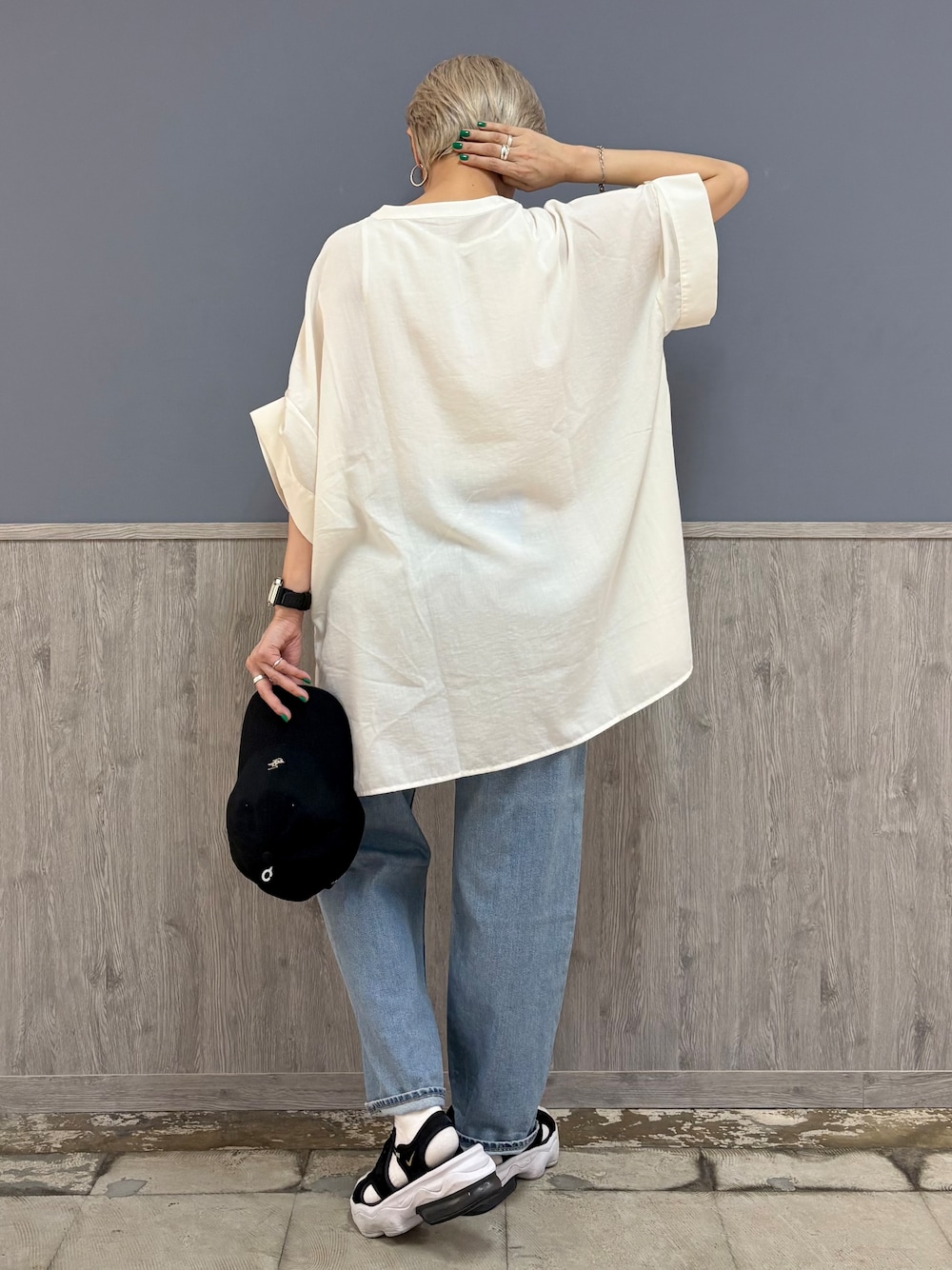 ブルー系のデニムパンツ、ブラック系のショルダーバッグ、ブラック系のキャップを着用したレディースの夏コーディネートの6枚目の写真