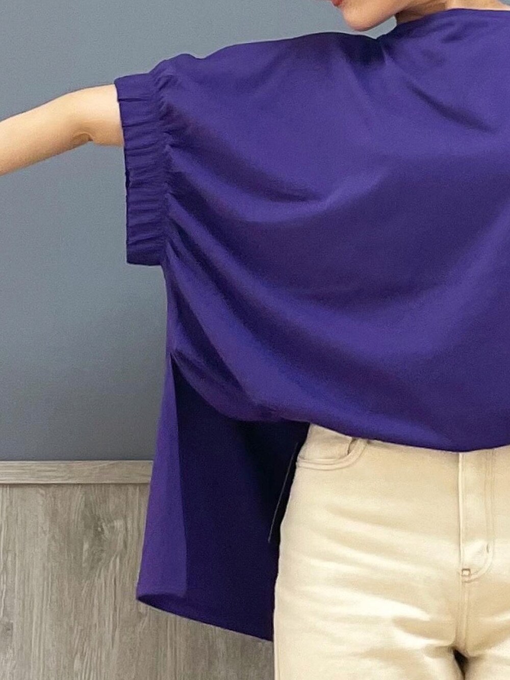 ホワイト系のデニムパンツ、ホワイト系のスニーカー、パープル系のトップスを着用したレディースの夏コーディネートの2枚目の写真