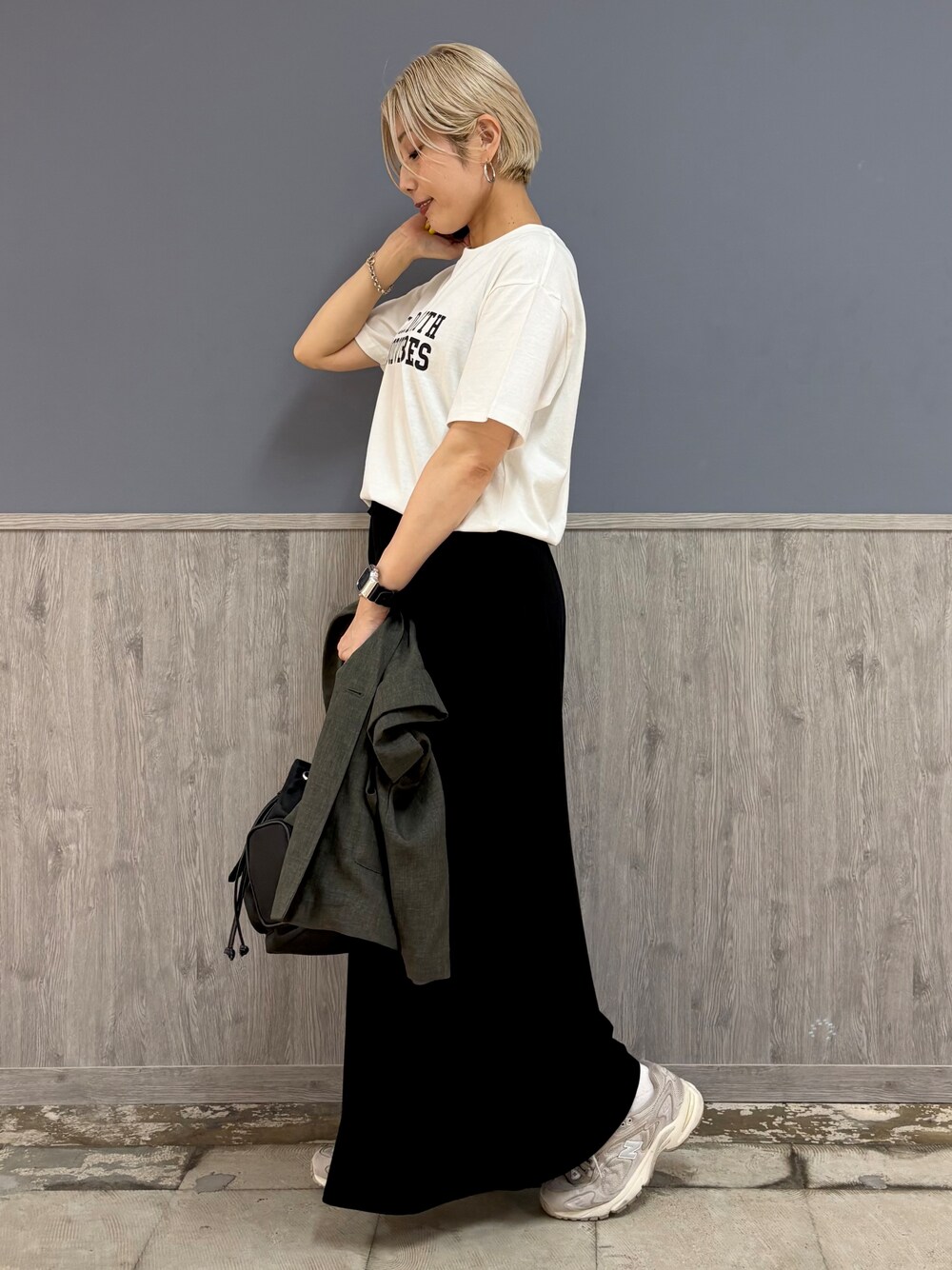 グレー系のテーラードジャケット、ホワイト系のTシャツ/カットソー、ブラック系のスカートを着用したレディースの夏コーディネートの6枚目の写真