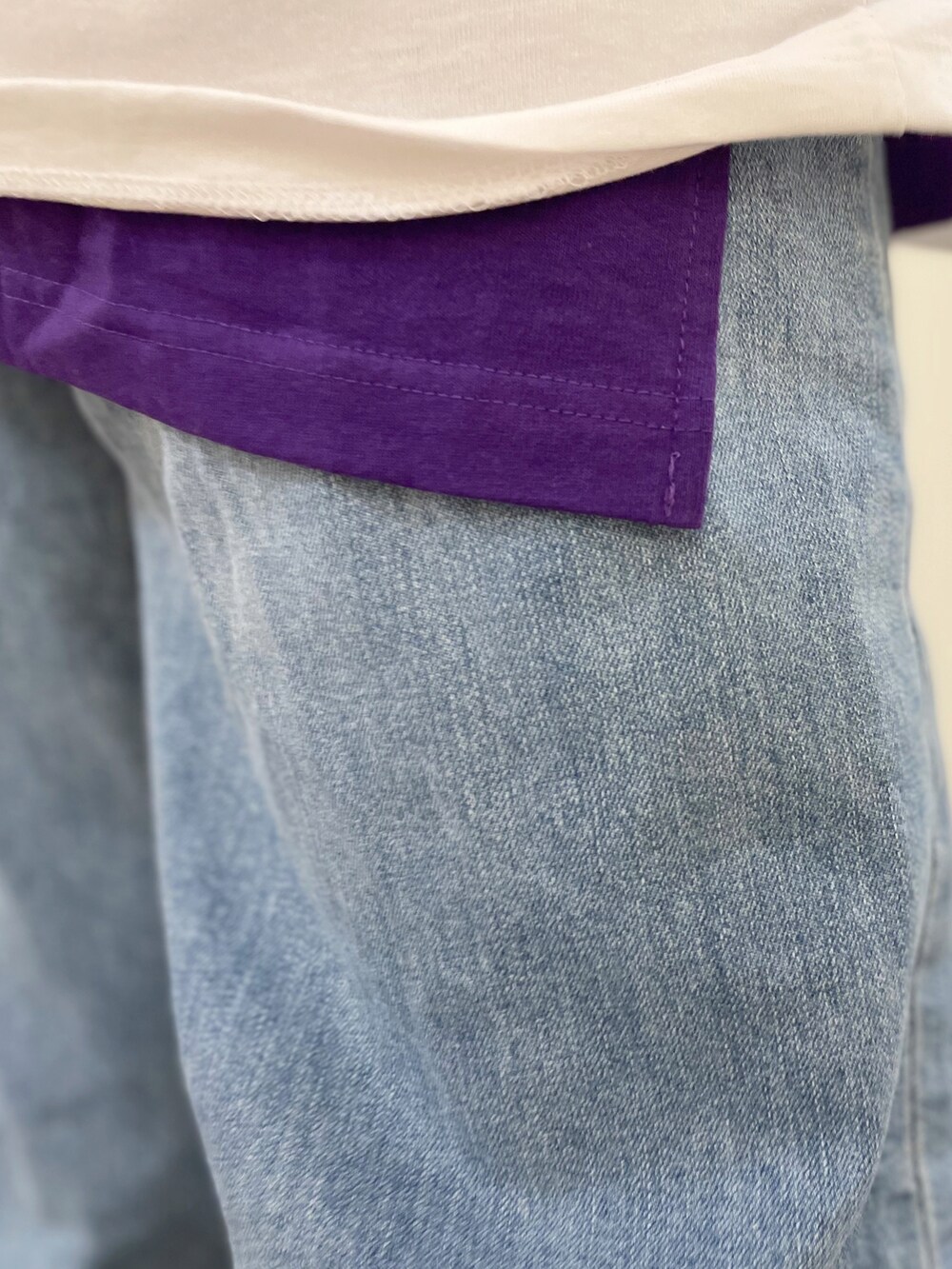 ブラック系のトートバッグ、ブルー系のデニムパンツ、ベージュ系のスニーカーを着用したレディースの春コーディネートの5枚目の写真