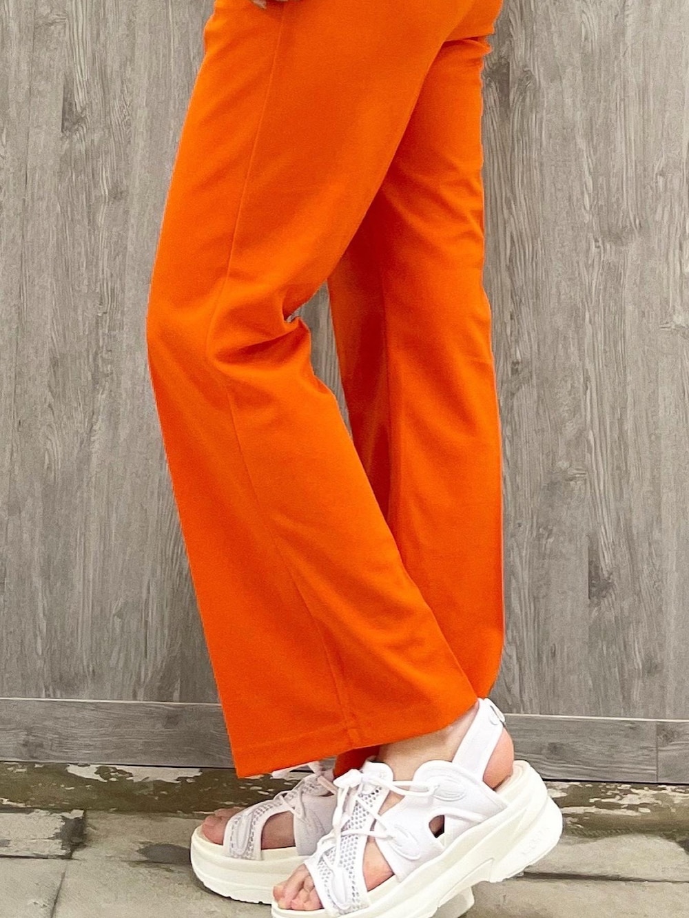 グレー系のTシャツ/カットソー、オレンジ系のパンツ、ブラウン系のショルダーバッグを着用したレディースの春コーディネートの3枚目の写真