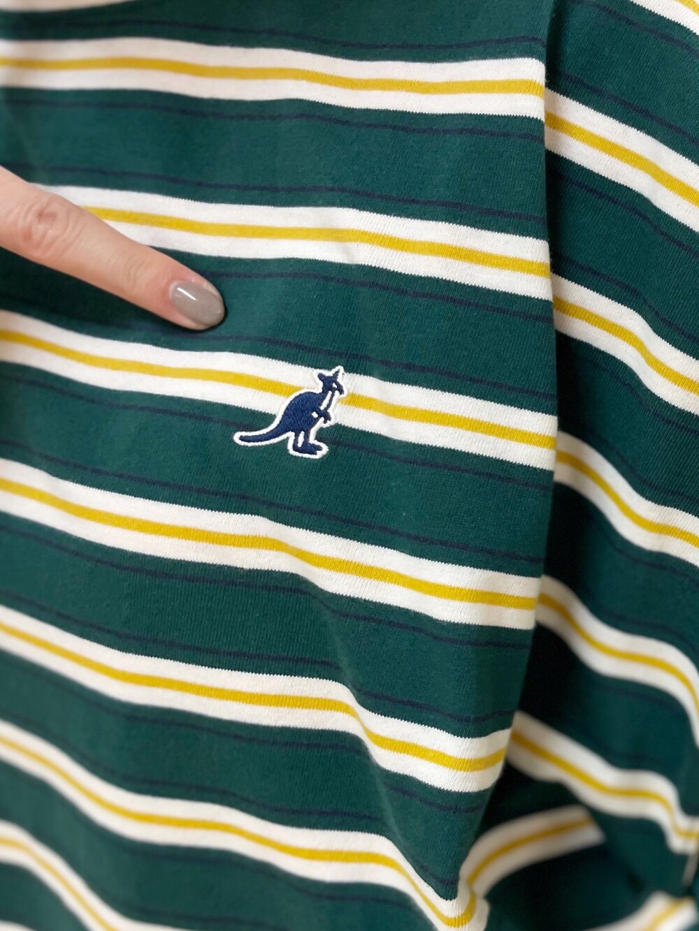 レッド系のトートバッグ、ブルー系のデニムパンツ、グリーン系のTシャツ/カットソーを着用したレディースの春コーディネートの5枚目の写真