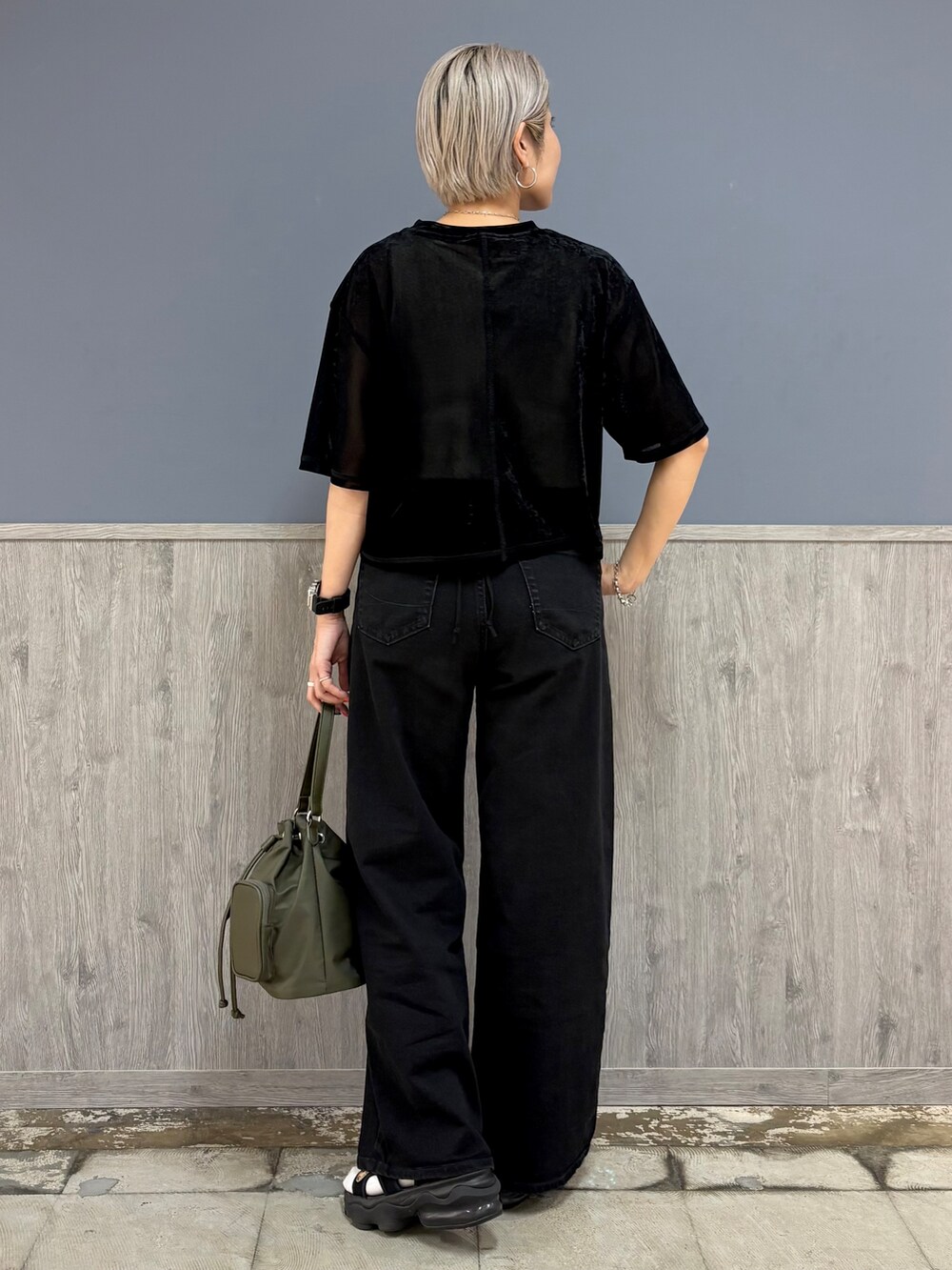 ブラック系のTシャツ/カットソー、ホワイト系のタンクトップ、ブラック系のデニムパンツを着用したレディースの秋コーディネートの5枚目の写真