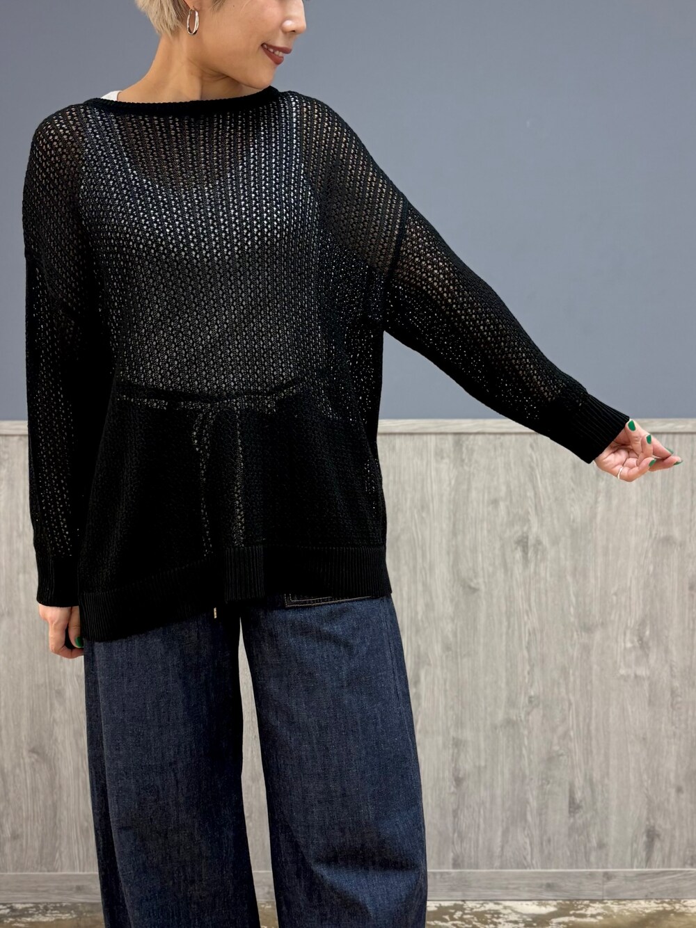ブラック系のニット/セーター、ホワイト系のタンクトップ、ブルー系のデニムパンツを着用したレディースの夏コーディネートの2枚目の写真