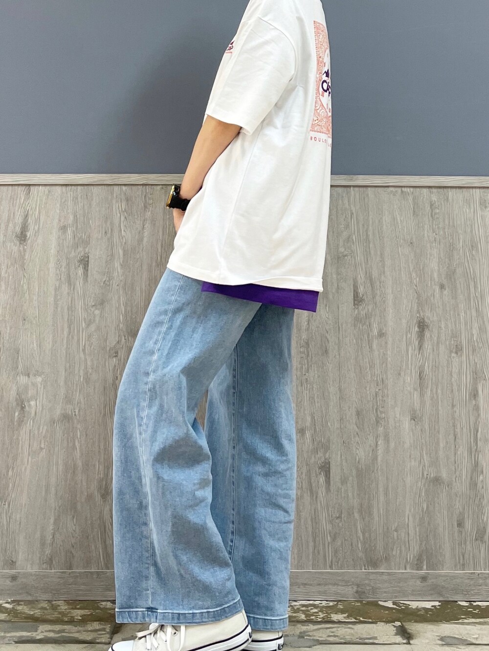 ブラック系のトートバッグ、ブルー系のデニムパンツ、ベージュ系のスニーカーを着用したレディースの春コーディネートの4枚目の写真