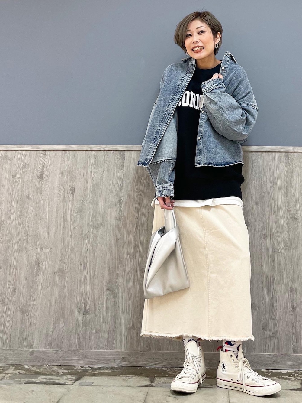 ホワイト系のスカート、ホワイト系のシューズ、シルバー系のショルダーバッグを着用したレディースの冬コーディネートの3枚目の写真