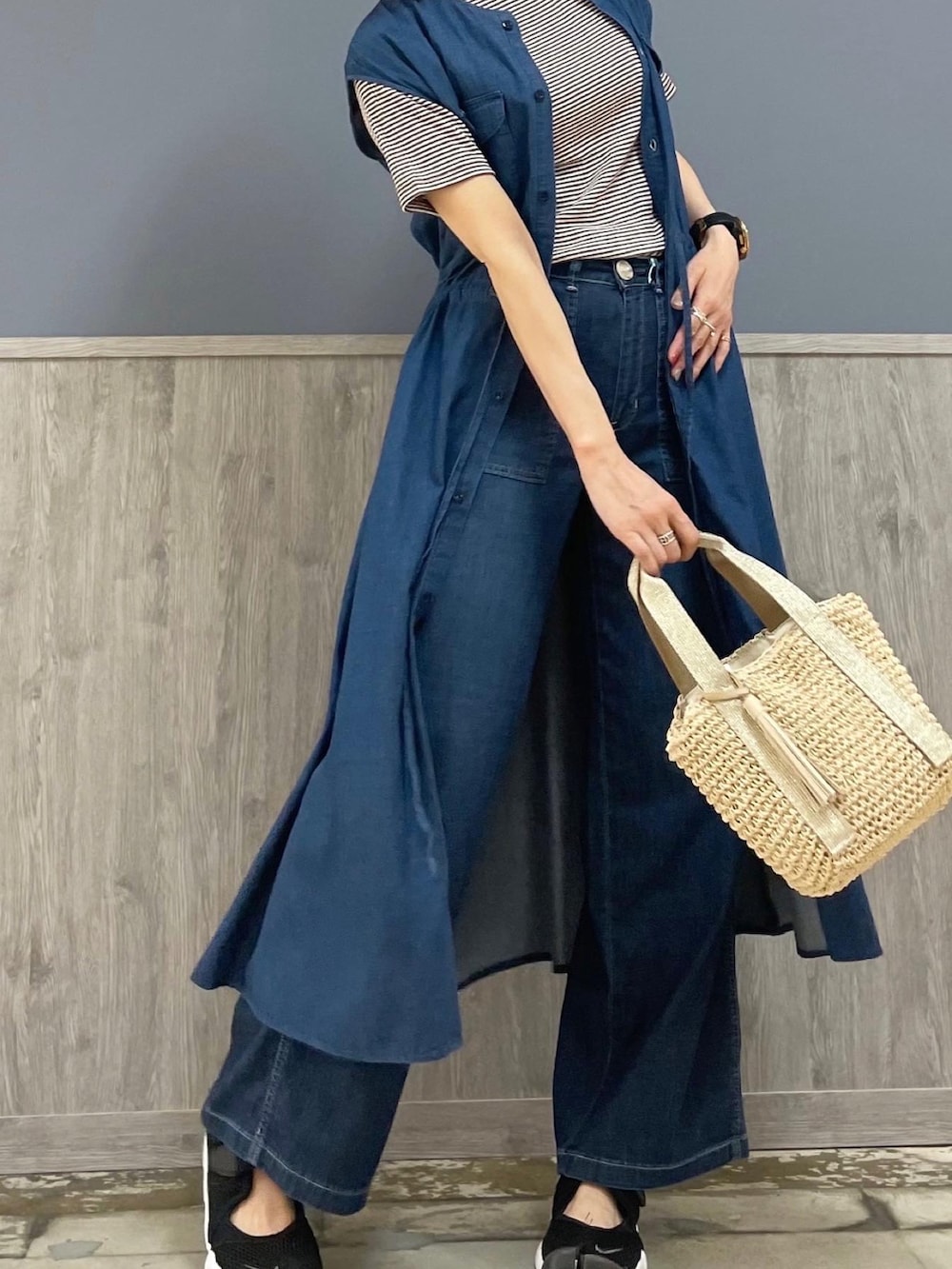 ベージュ系のショルダーバッグ、ブルー系のデニムパンツ、ブラウン系のTシャツ/カットソーを着用したレディースの夏コーディネートの2枚目の写真