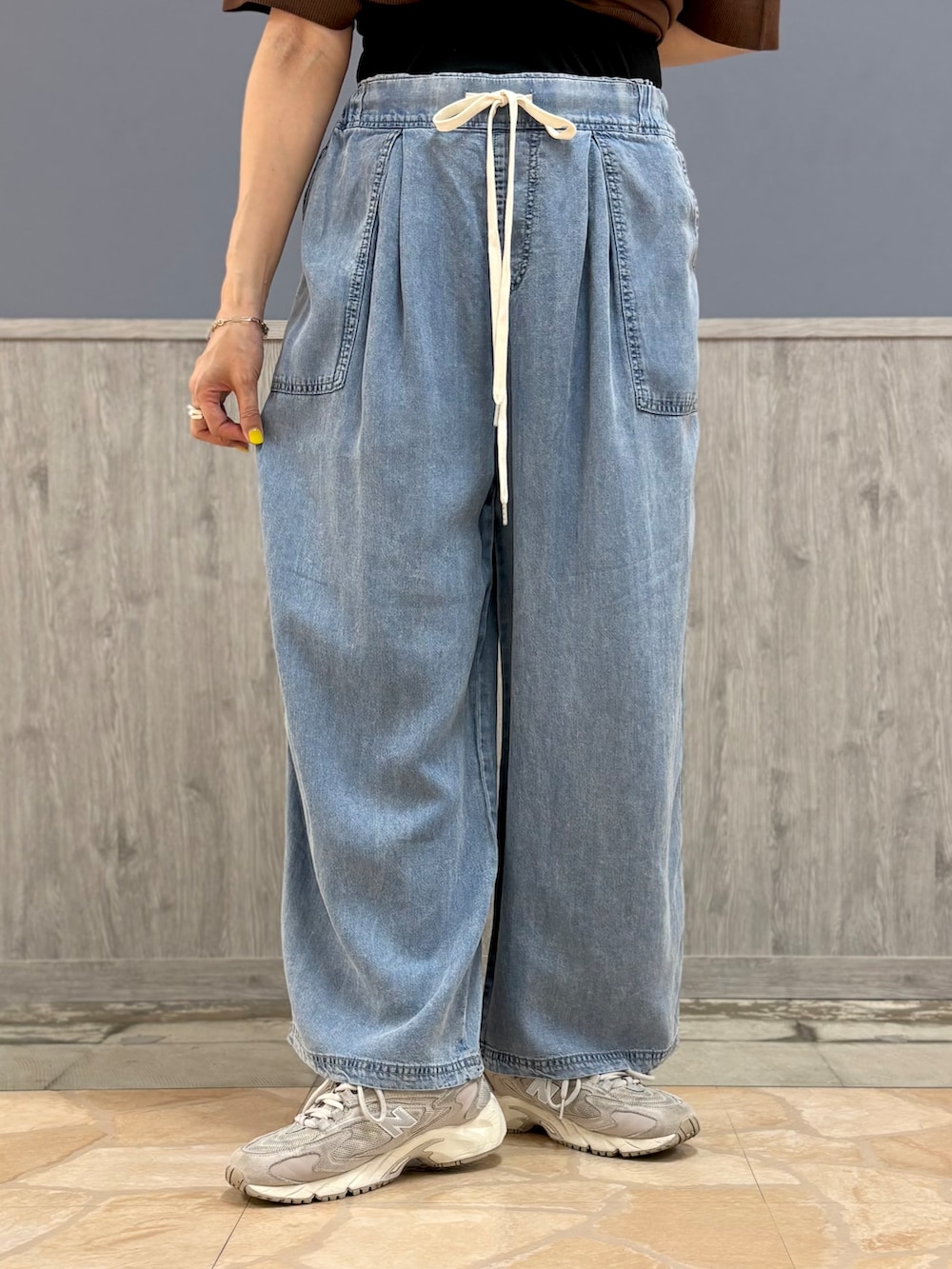 ブラウン系のニット/セーター、ブルー系のデニムパンツ、ベージュ系のキャップを着用したレディースの夏コーディネートの6枚目の写真