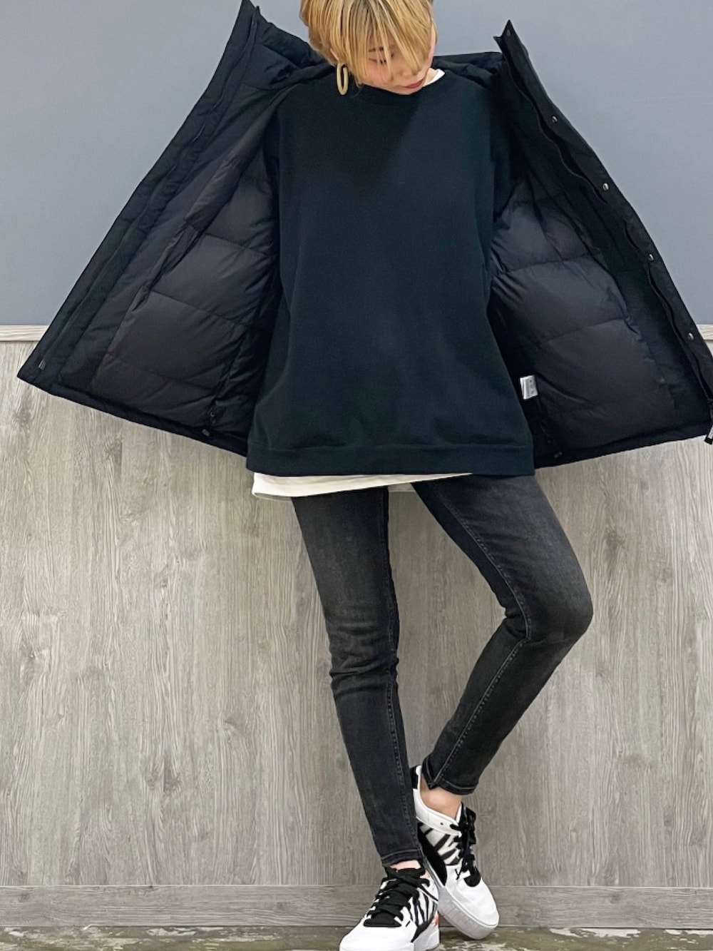 ブラック系のデニムパンツ、ブラック系のダウンジャケット/コート、ホワイト系のTシャツ/カットソーを着用したレディースの秋コーディネートの3枚目の写真