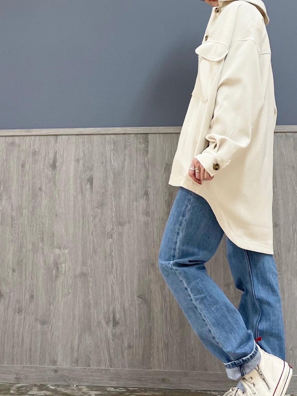 ブラウン系のショルダーバッグ、ホワイト系のシューズ、ブルー系のデニムパンツを着用したレディースの冬コーディネートの3枚目の写真