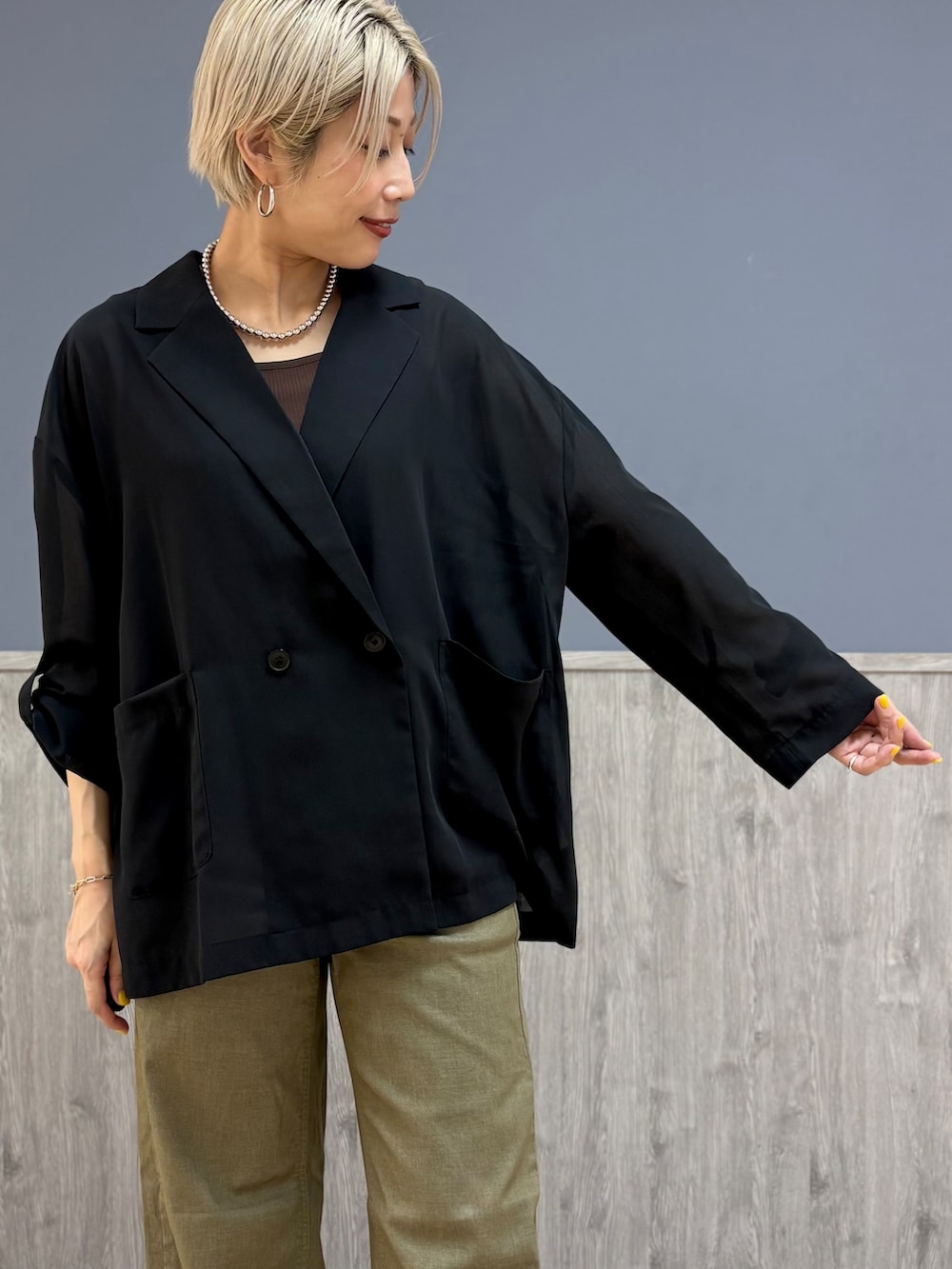 ブラウン系のタンクトップ、ベージュ系のその他パンツ、ブラック系のショルダーバッグを着用したレディースの夏コーディネートの2枚目の写真