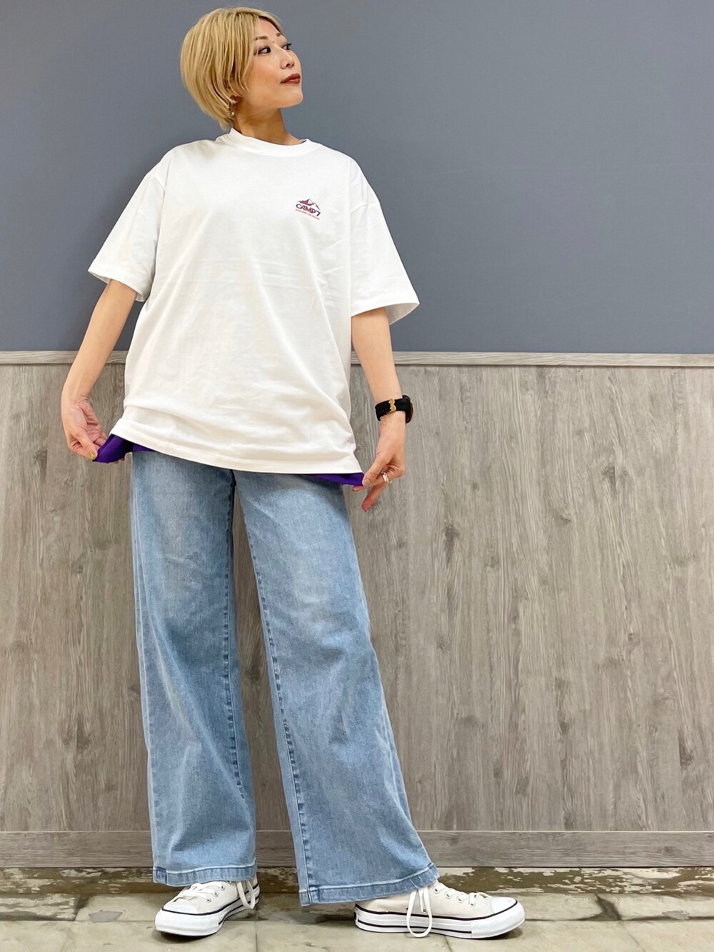 ブラック系のトートバッグ、ブルー系のデニムパンツ、ベージュ系のスニーカーを着用したレディースの春コーディネートの3枚目の写真