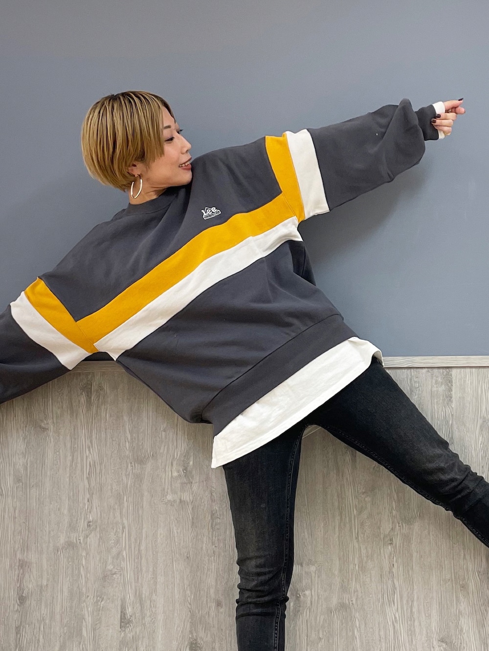 ブラック系のデニムパンツ、ベージュ系のトートバッグ、ブラック系のスニーカーを着用したレディースの冬コーディネートの2枚目の写真