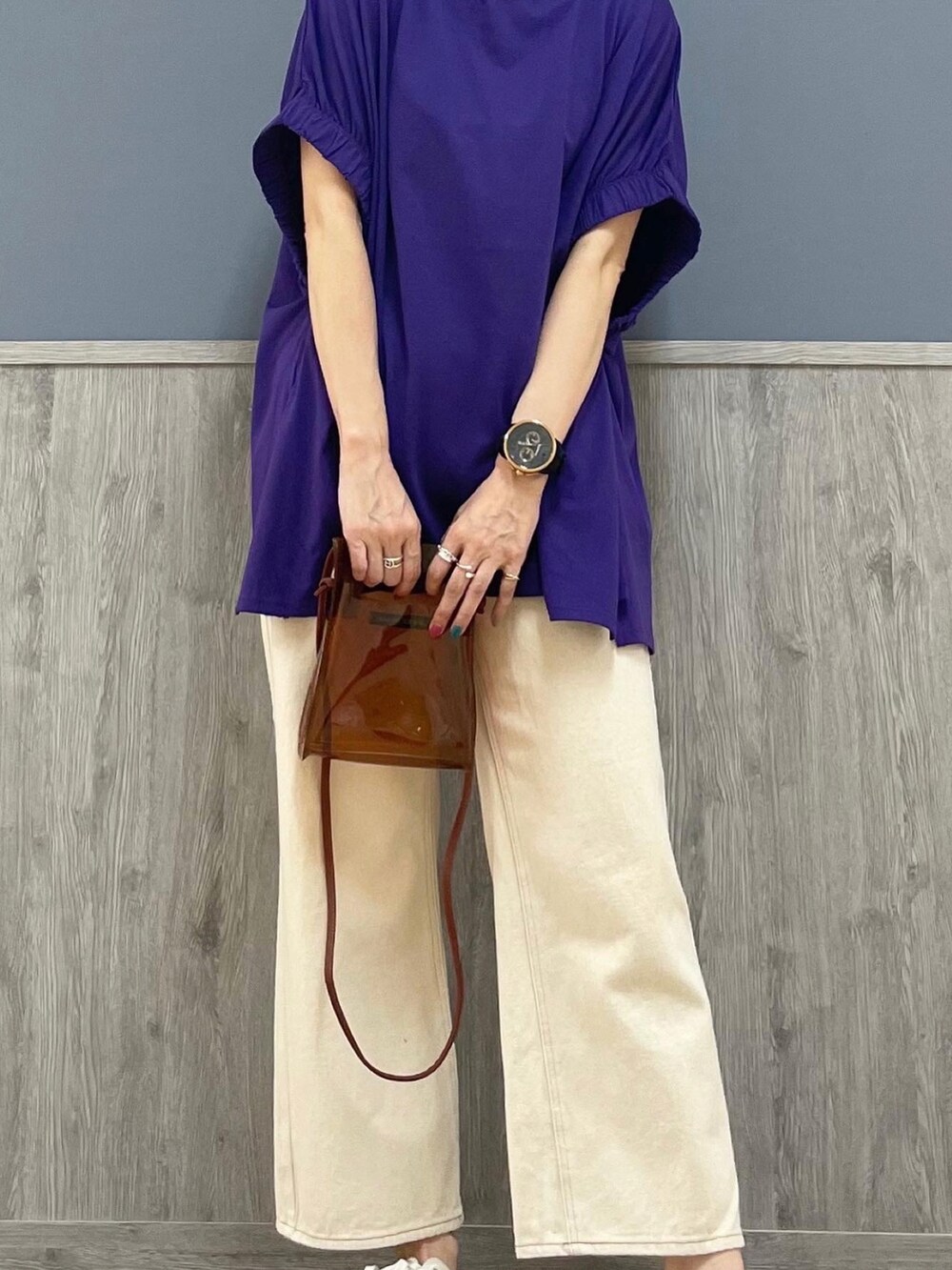 ホワイト系のデニムパンツ、ホワイト系のスニーカー、パープル系のトップスを着用したレディースの夏コーディネートの3枚目の写真