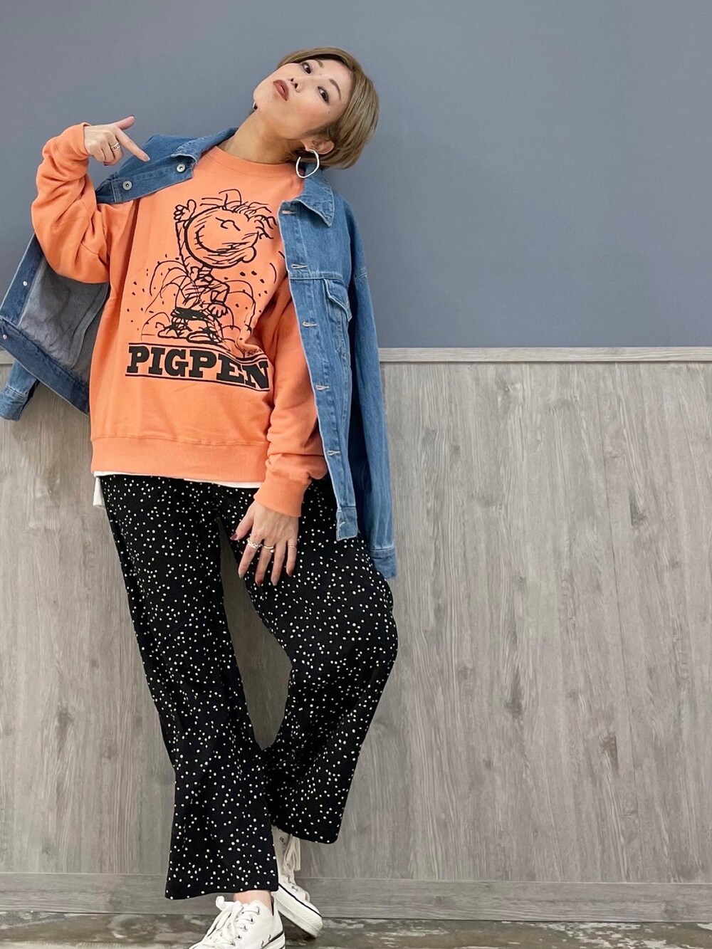 ブラック系のその他パンツ、オレンジ系のスウェット、ブルー系のデニムジャケットを着用したレディースの春コーディネートの3枚目の写真