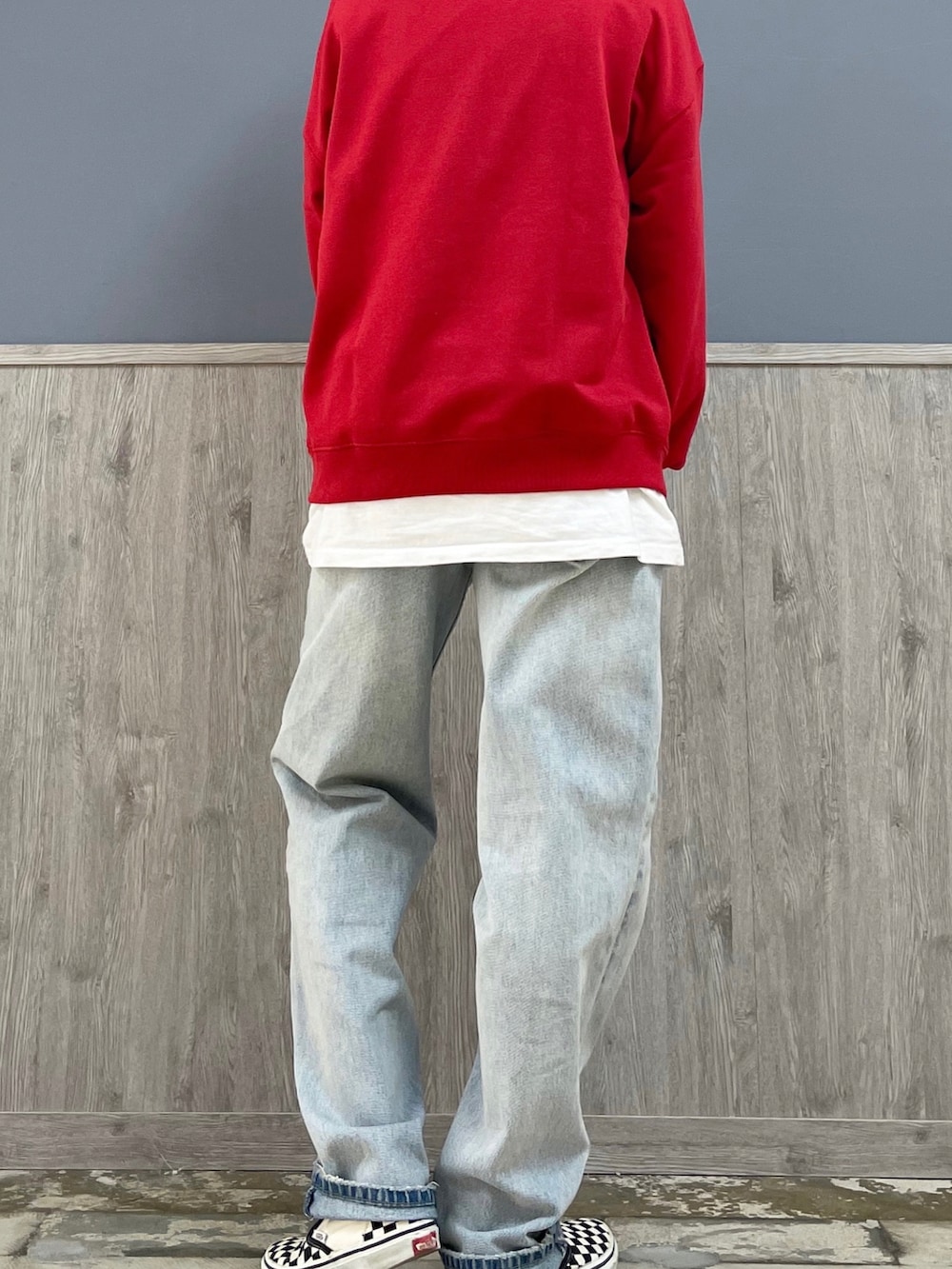 ブラック系のショルダーバッグ、レッド系のスウェット、ブルー系のデニムパンツを着用したレディースの春コーディネートの4枚目の写真