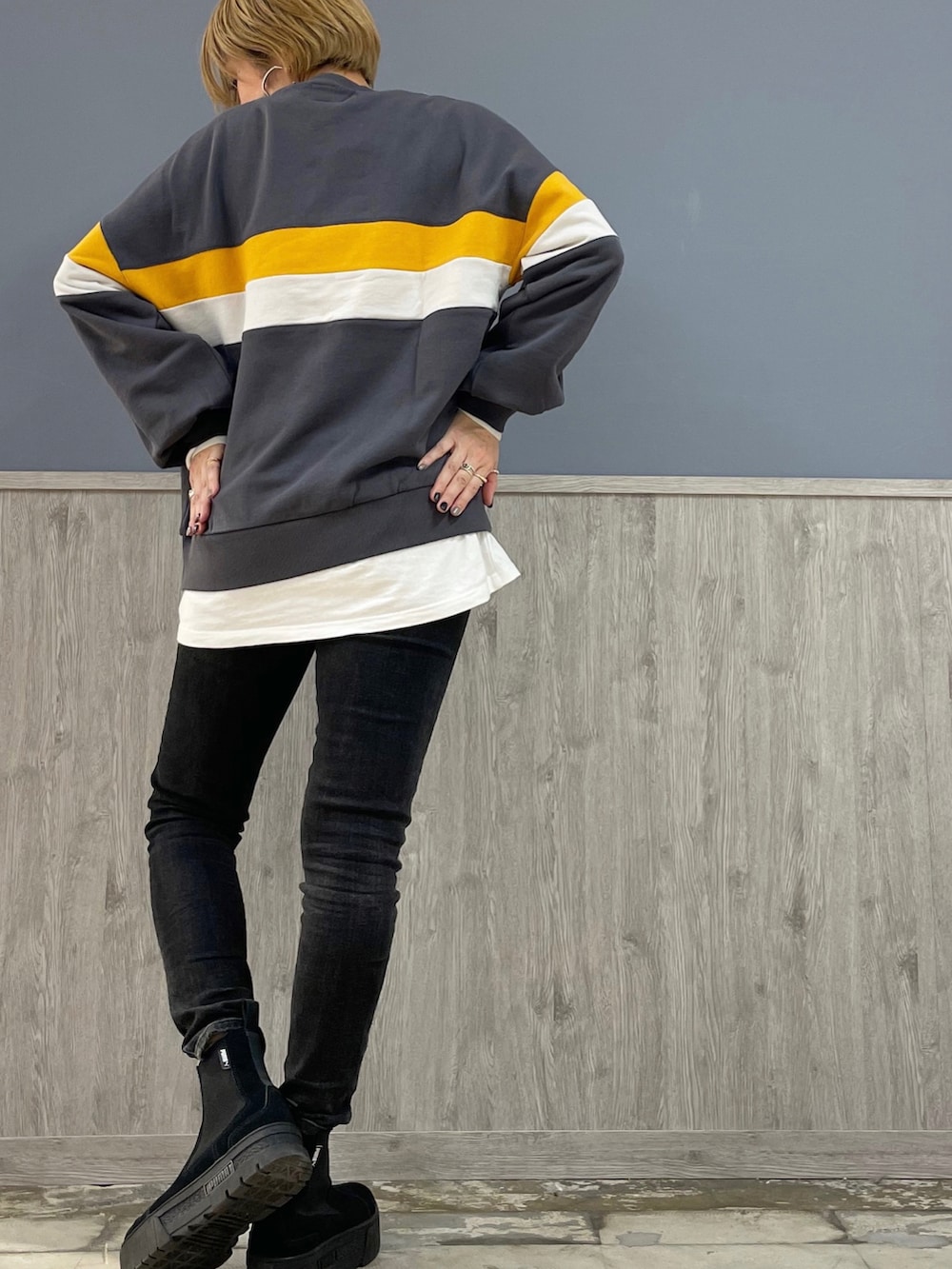 ブラック系のデニムパンツ、ベージュ系のトートバッグ、ブラック系のスニーカーを着用したレディースの冬コーディネートの4枚目の写真