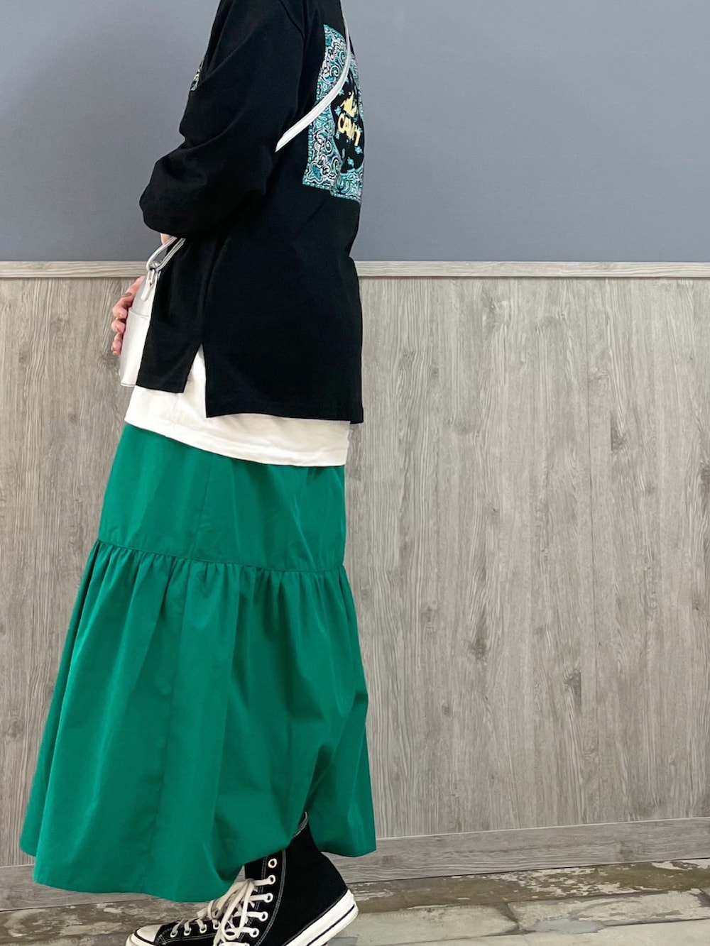 ブラック系のスニーカー、グリーン系のスカート、ブルー系のデニムジャケットを着用したレディースの春コーディネートの2枚目の写真