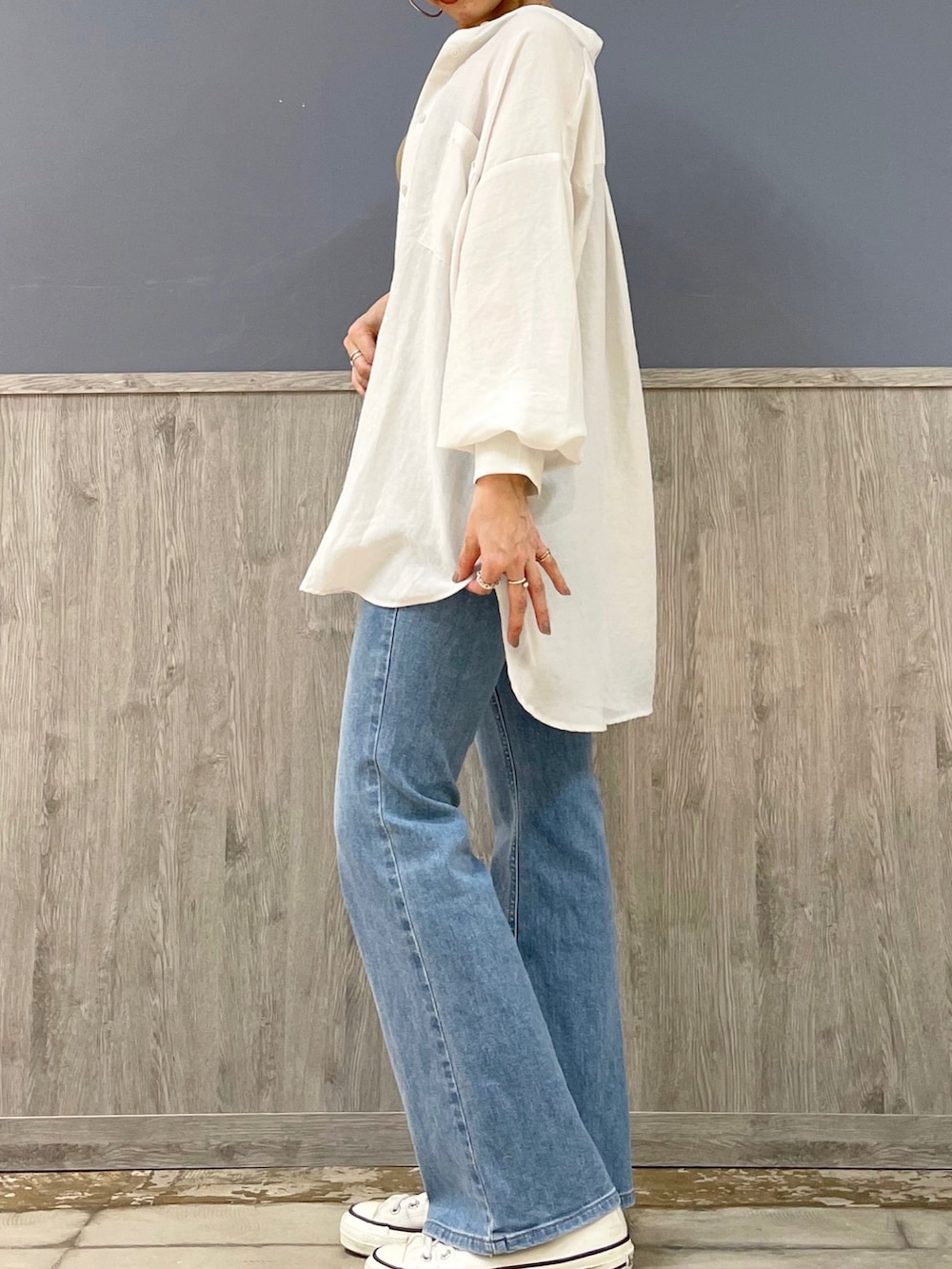 ブルー系のデニムパンツ、ベージュ系のショルダーバッグ、ベージュ系のタンクトップを着用したレディースの春コーディネートの3枚目の写真