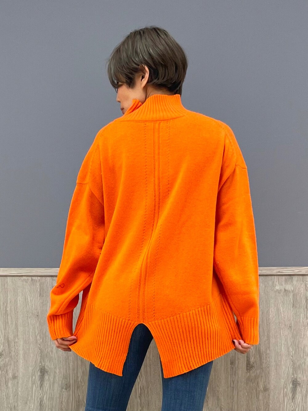 オレンジ系のニット/セーター、ブラック系のその他アウター、ベージュ系のトートバッグを着用したレディースの冬コーディネートの4枚目の写真