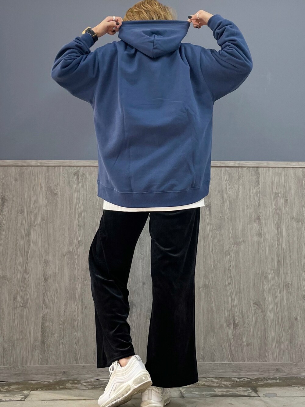 ブラック系のその他パンツ、ブルー系のパーカー、ブラウン系のショルダーバッグを着用したレディースの冬コーディネートの2枚目の写真