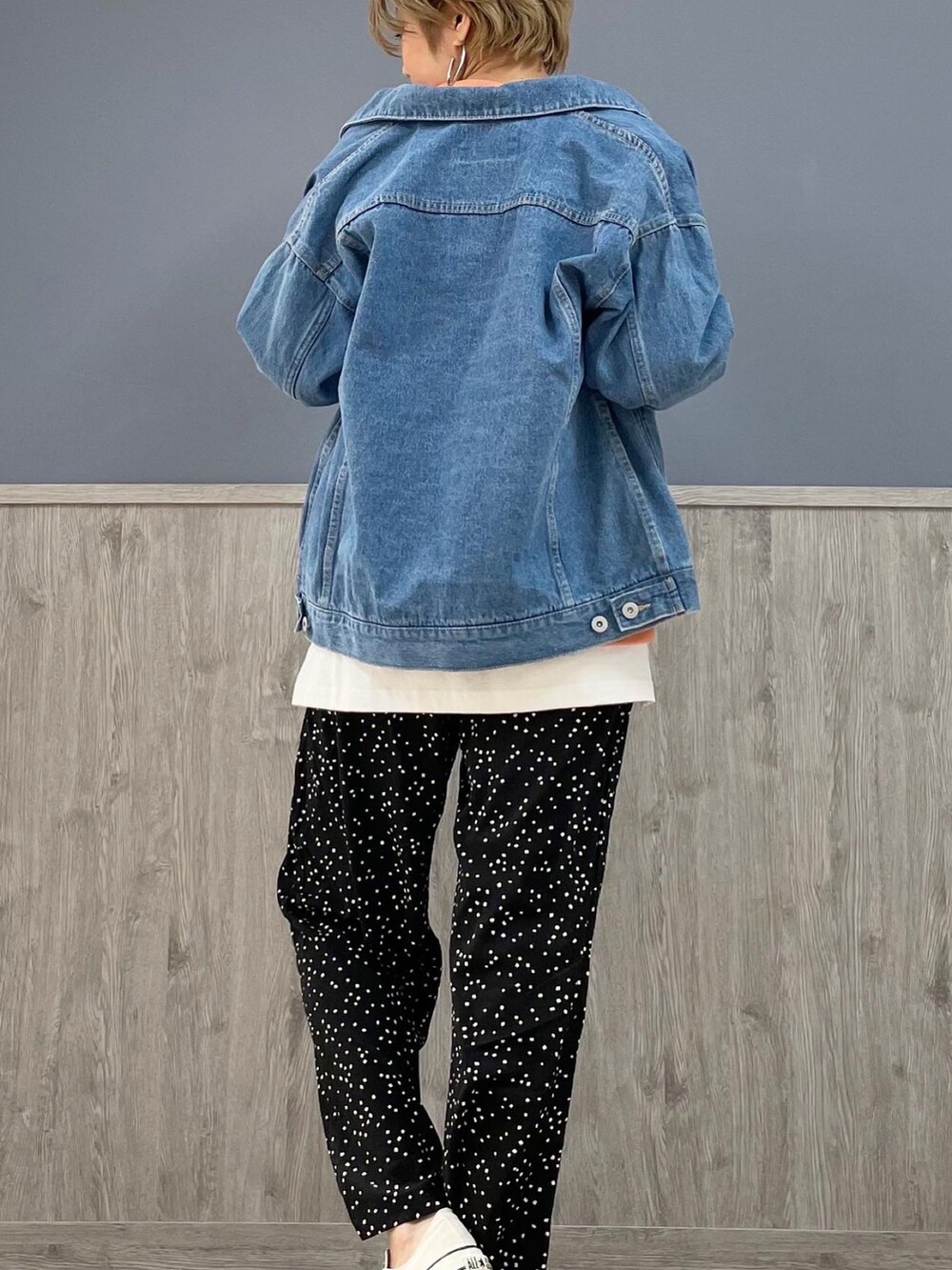 ブラック系のその他パンツ、オレンジ系のスウェット、ブルー系のデニムジャケットを着用したレディースの春コーディネートの4枚目の写真