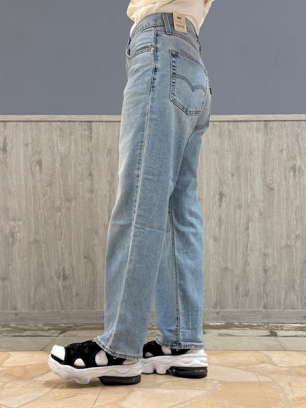 ブルー系のデニムパンツ、ブラック系のショルダーバッグ、ブラック系のキャップを着用したレディースの夏コーディネートの8枚目の写真