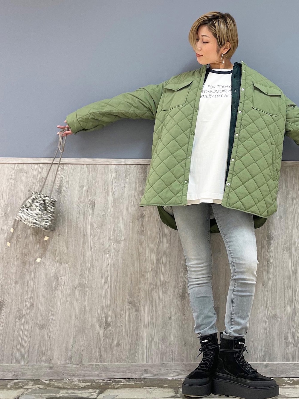 グレー系のショルダーバッグ、グレー系のデニムパンツ、ブルー系のTシャツ/カットソーを着用したレディースの冬コーディネートの3枚目の写真