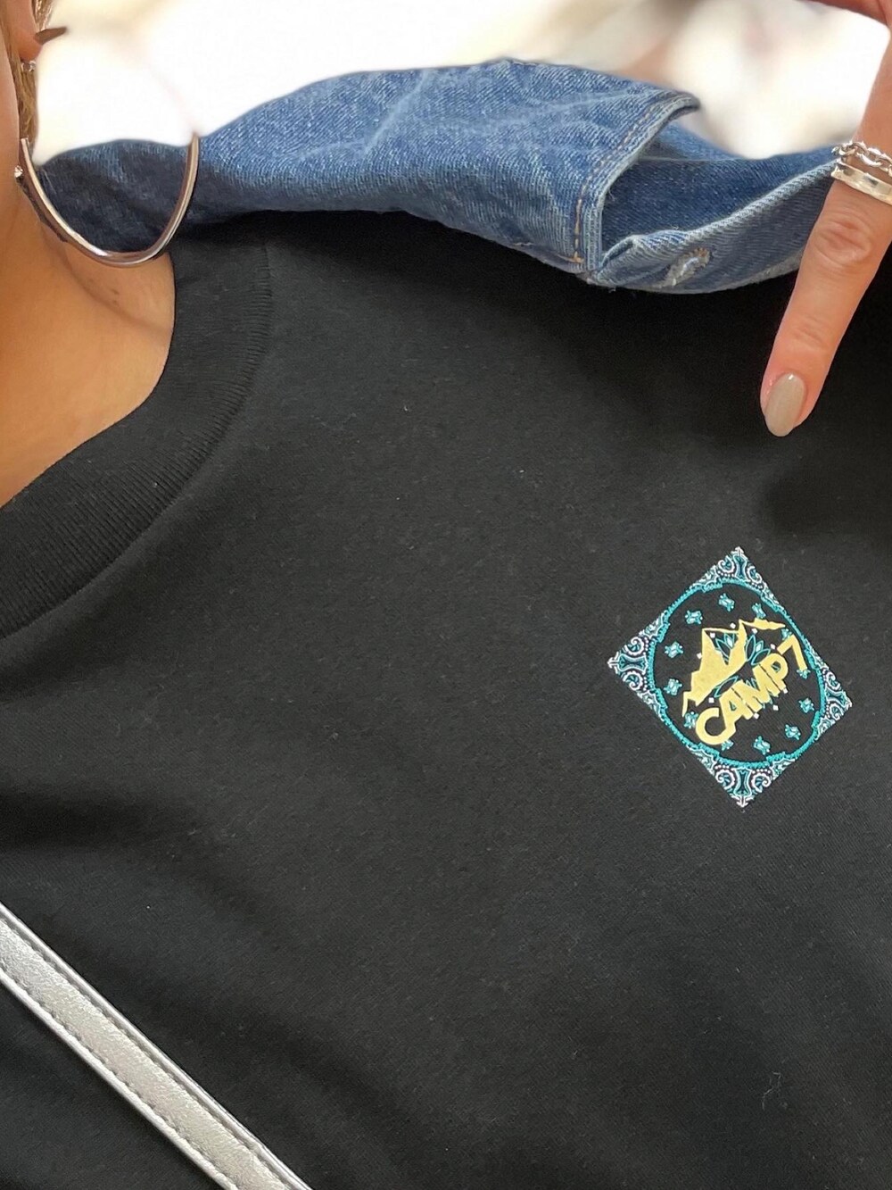 ブラック系のスニーカー、グリーン系のスカート、ブルー系のデニムジャケットを着用したレディースの春コーディネートの4枚目の写真