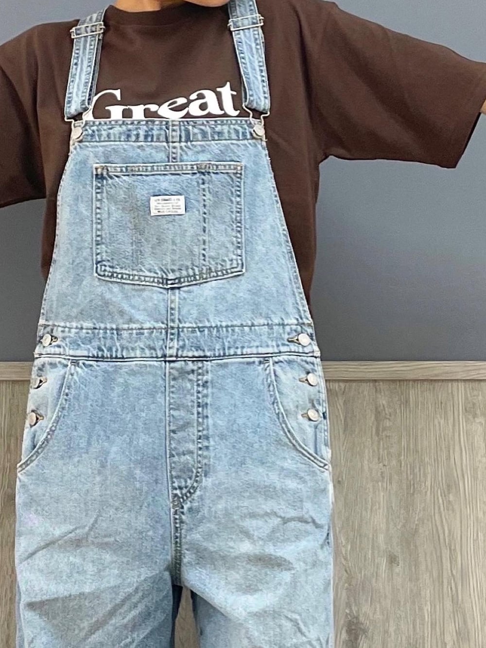 ブラウン系のバッグ、ブラック系のサンダル、ブラウン系のTシャツ/カットソーを着用したレディースの夏コーディネートの2枚目の写真