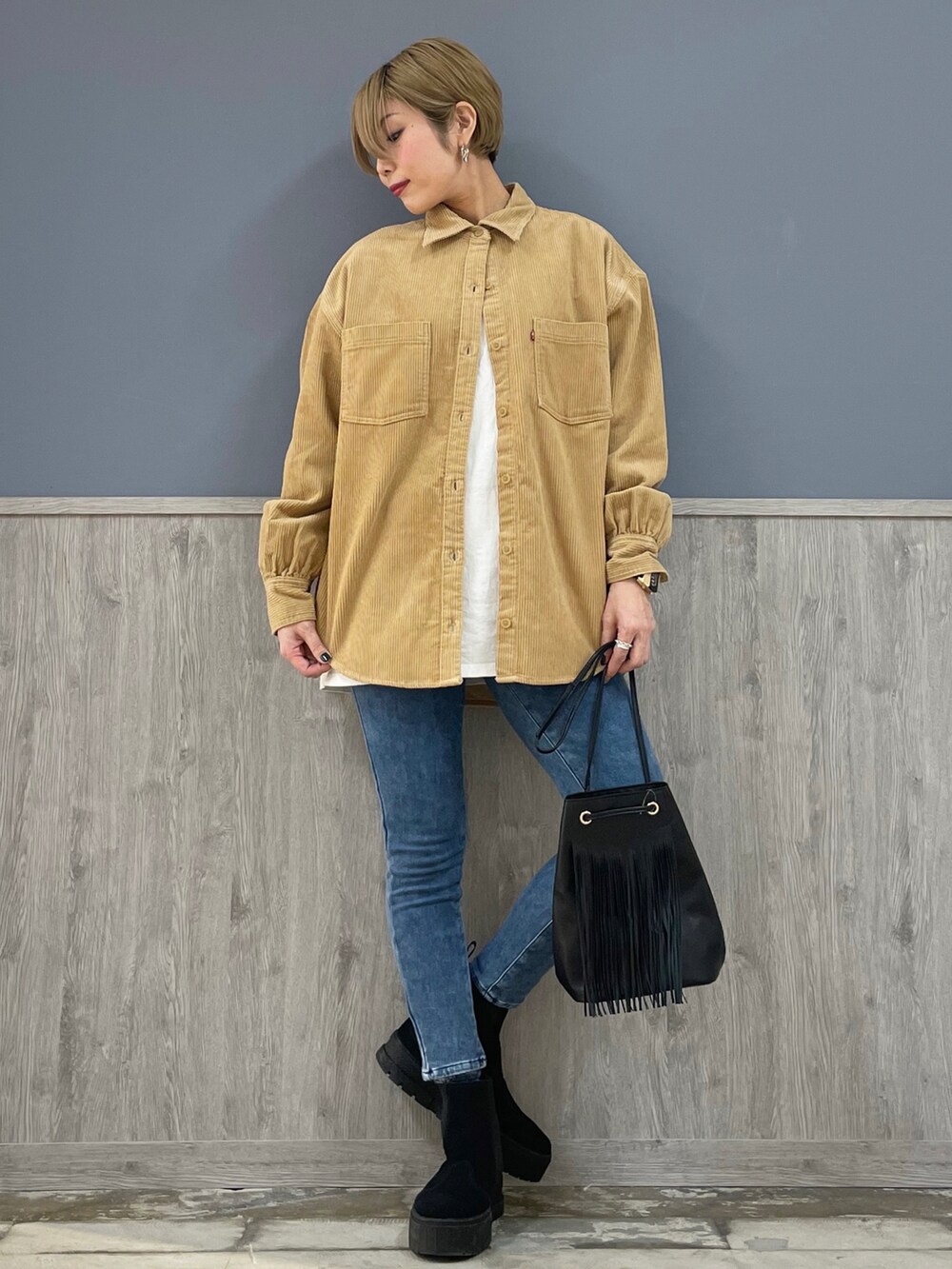 ブラウン系のシャツ/ブラウス、ホワイト系のTシャツ/カットソー、ブラック系のバッグを着用したレディースの冬コーディネートの5枚目の写真