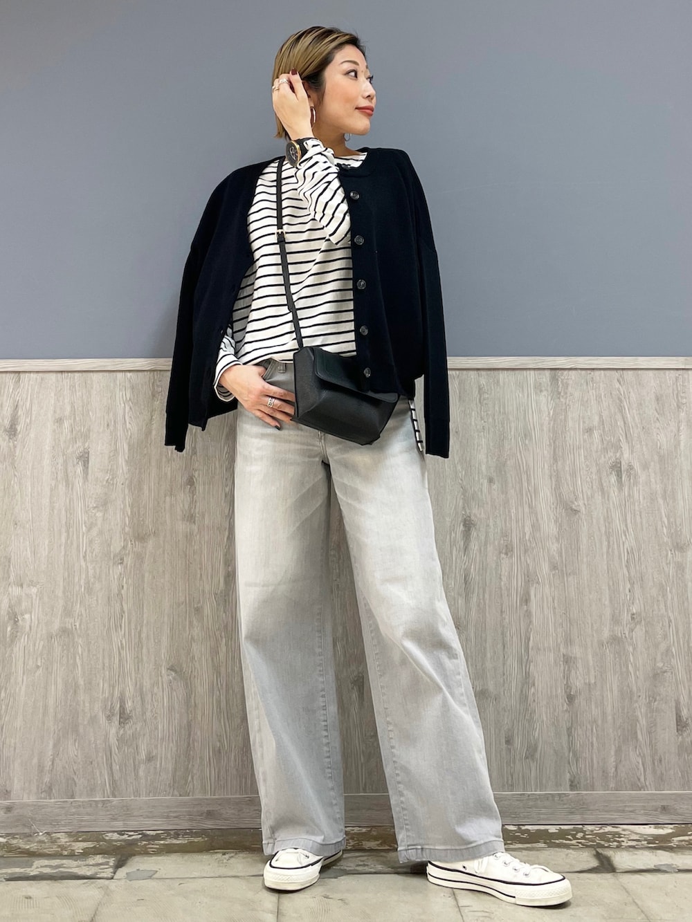 グレー系のデニムパンツ、ブラック系のカーディガン/ボレロ、ブラック系のTシャツ/カットソーを着用したレディースの春コーディネートの2枚目の写真