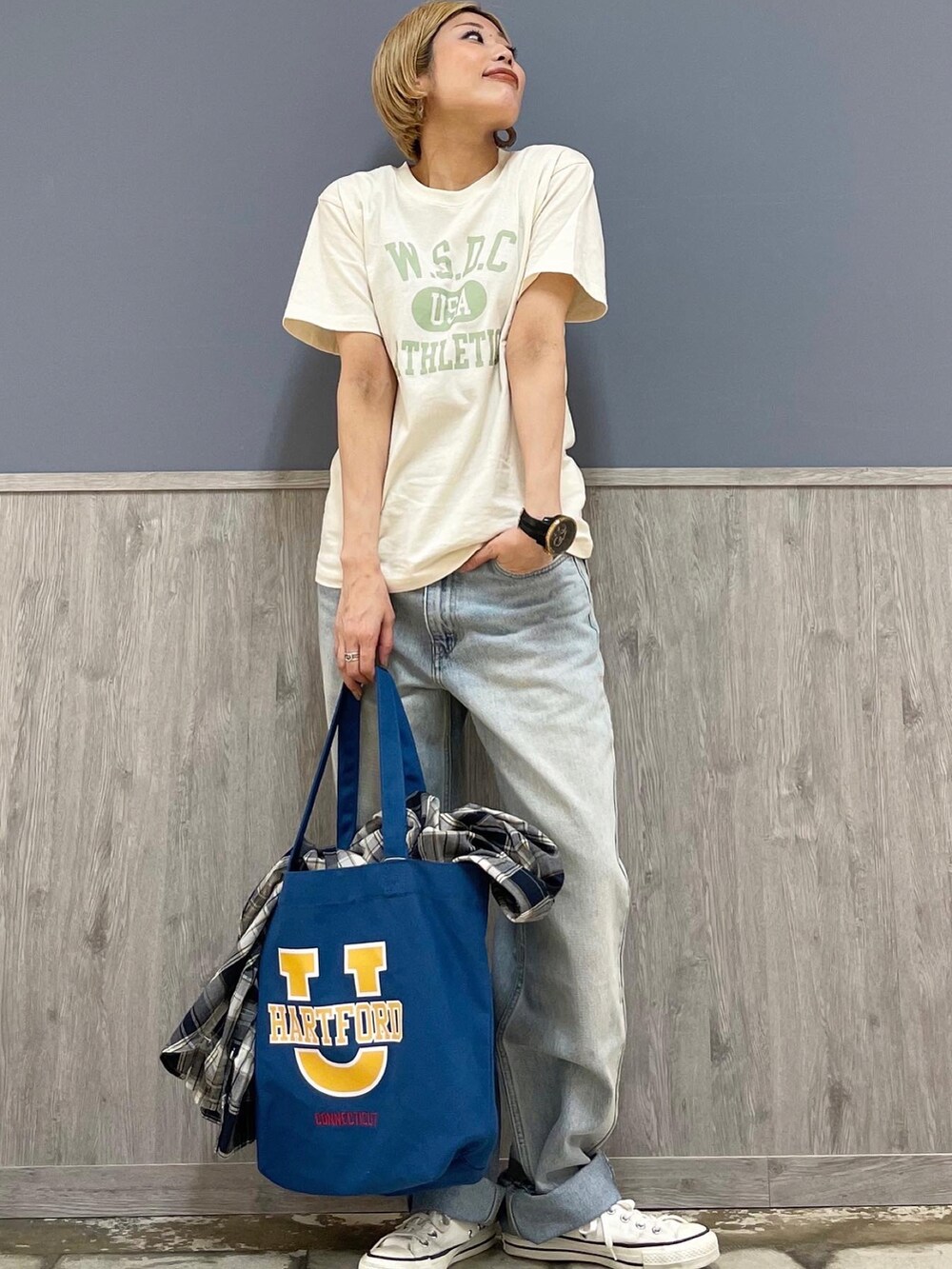 ブルー系のトートバッグ、ブルー系のデニムパンツ、ホワイト系のTシャツ/カットソーを着用したレディースの春コーディネートの4枚目の写真