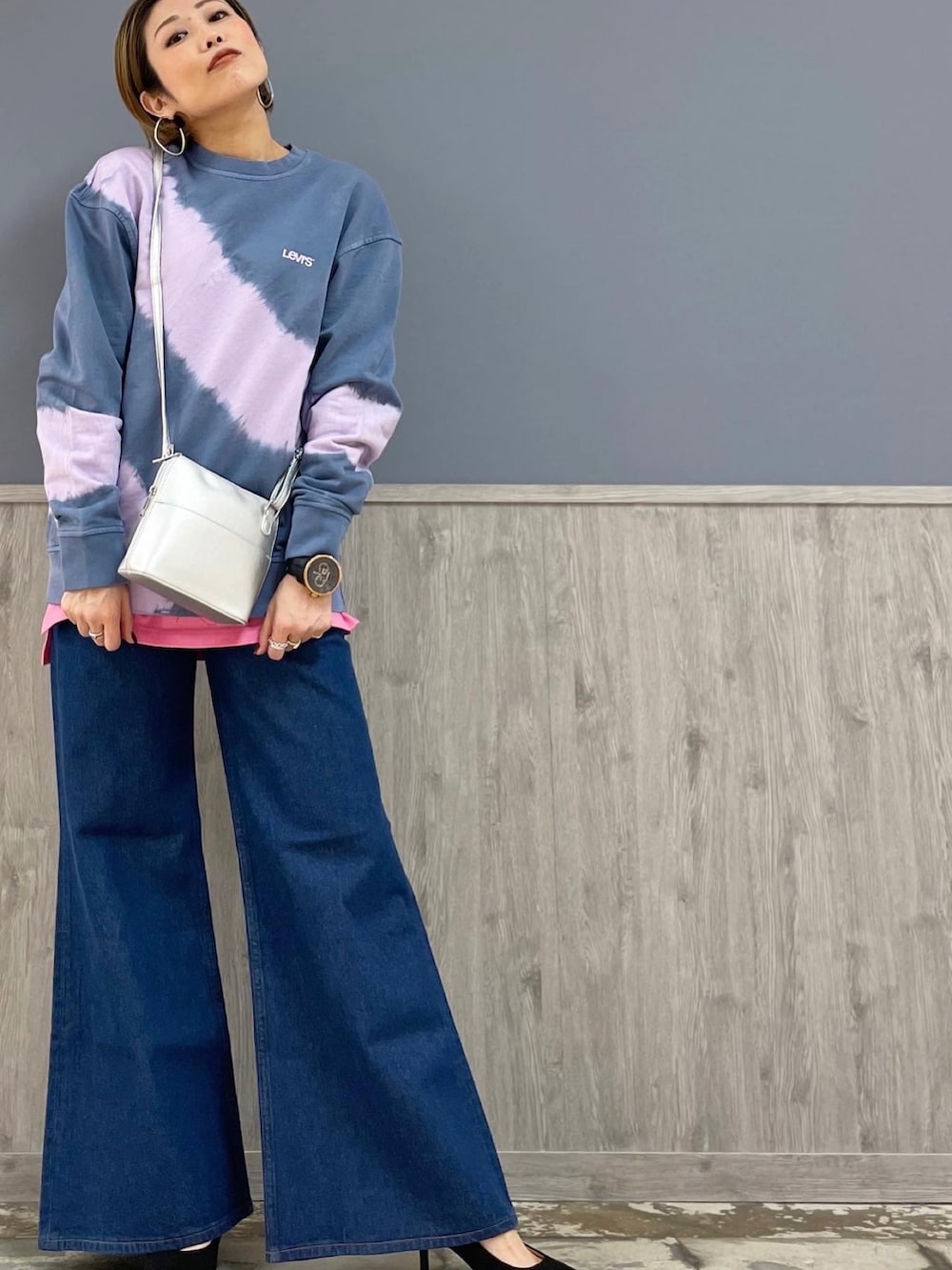 ブルー系のデニムパンツ、シルバー系のショルダーバッグ、パープル系のトップスを着用したレディースの春コーディネートの3枚目の写真